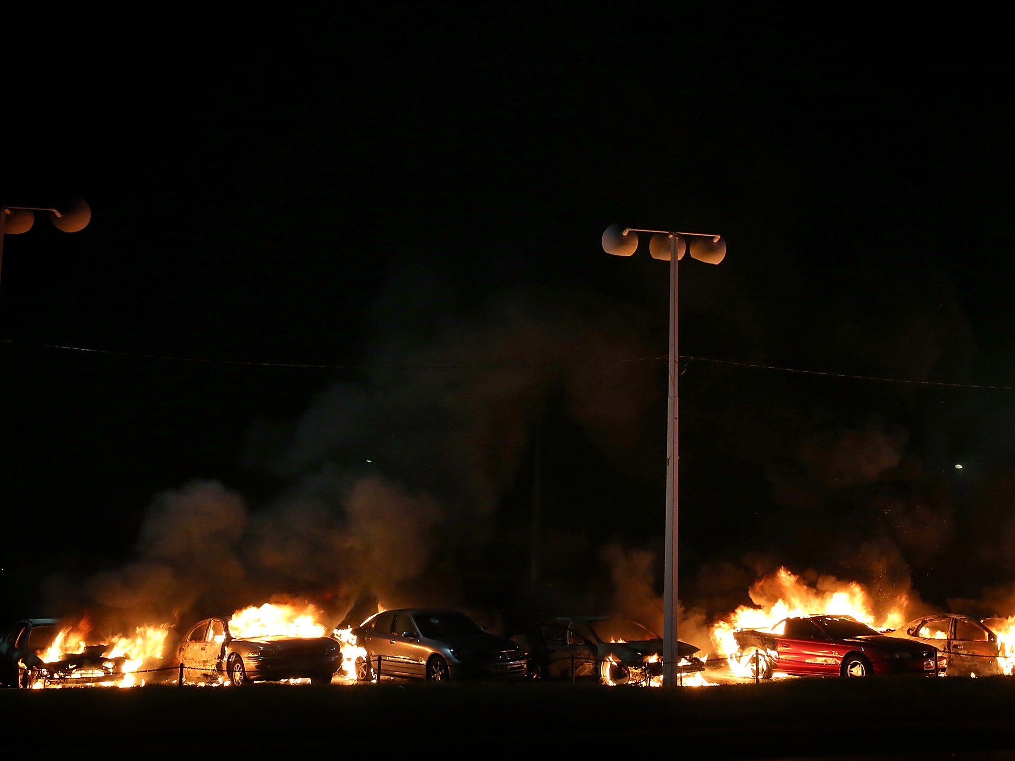 A row of cars burn at a used car lot during a demonstration on November 25, 2014 in Ferguson, Missouri.