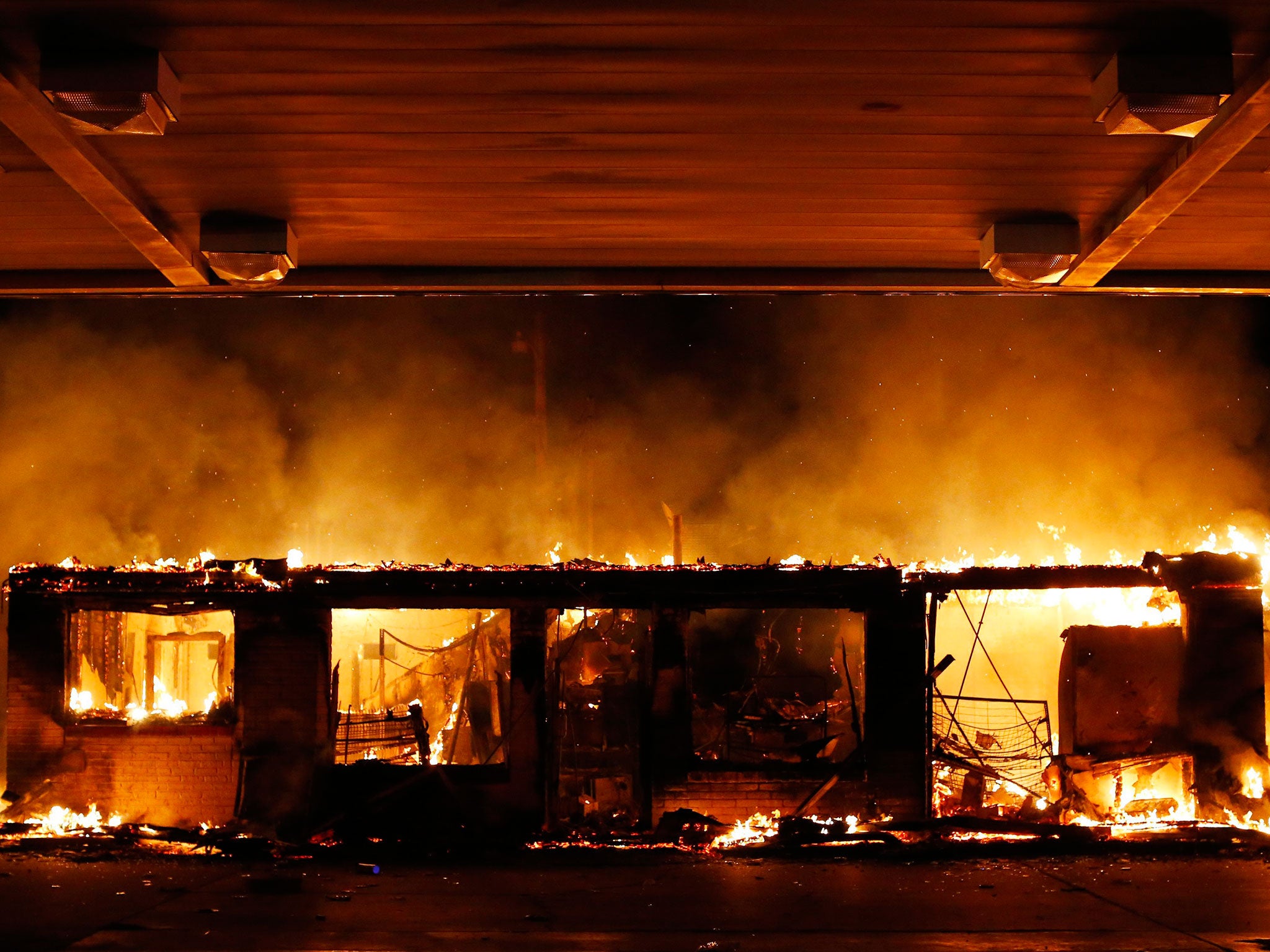 A gas station burns as demonstrators protest the Grand Jury decision not to indict police officer Darren Wilson over the shooting death of Michael Brown in Ferguson