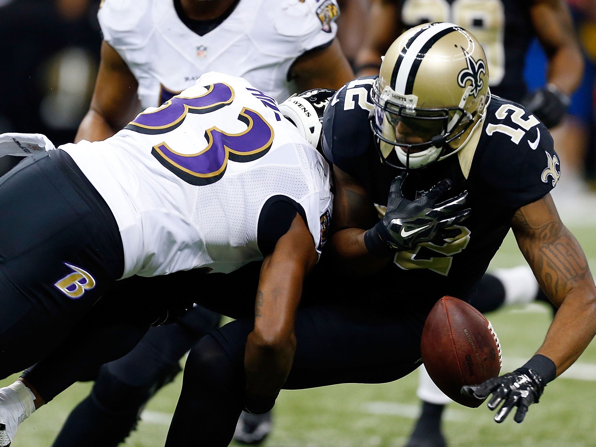 Marques Colston loses control of the ball as he is tackled by Will Hill