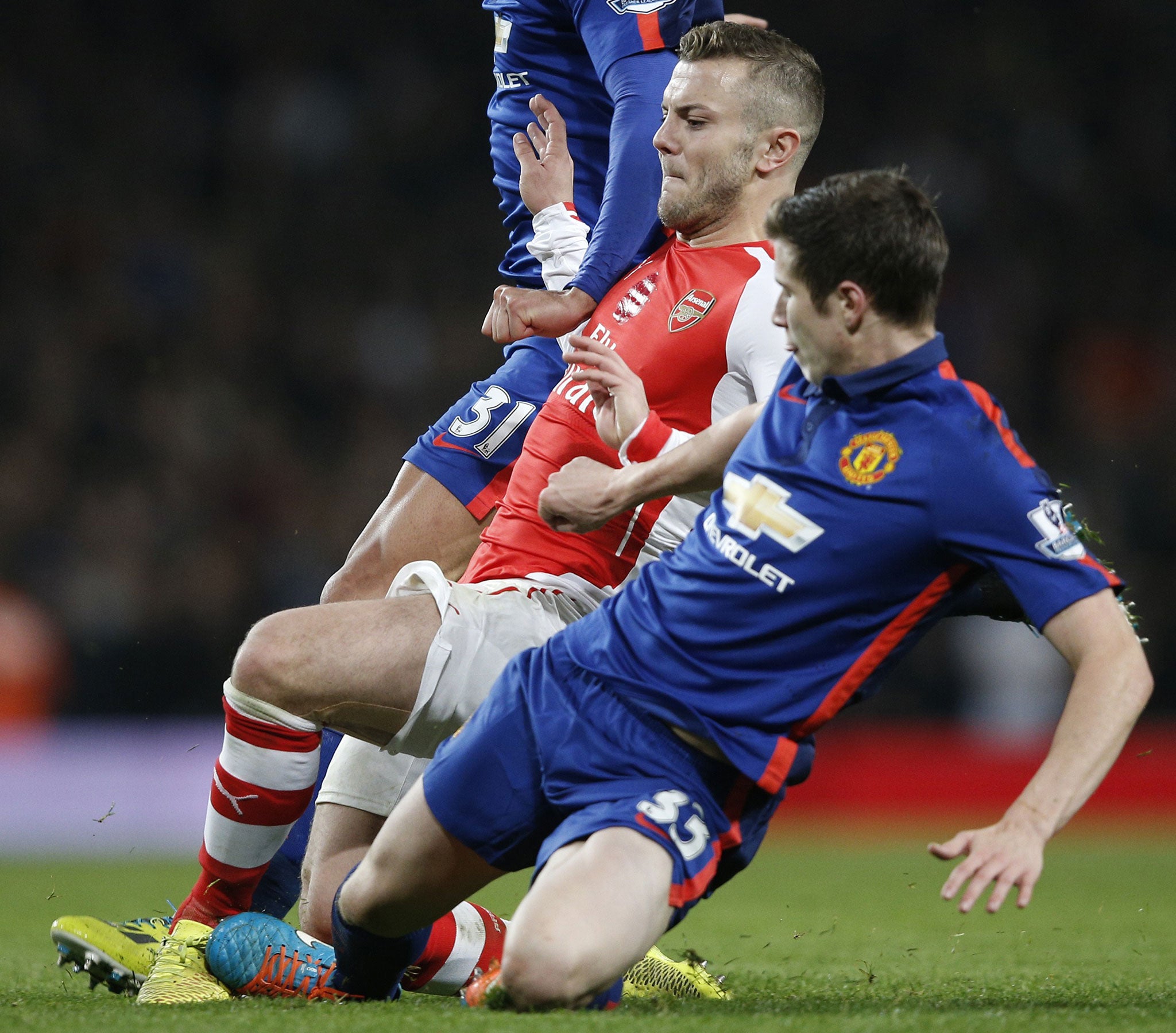 Wilshere is tackled by United defender Paddy McNair