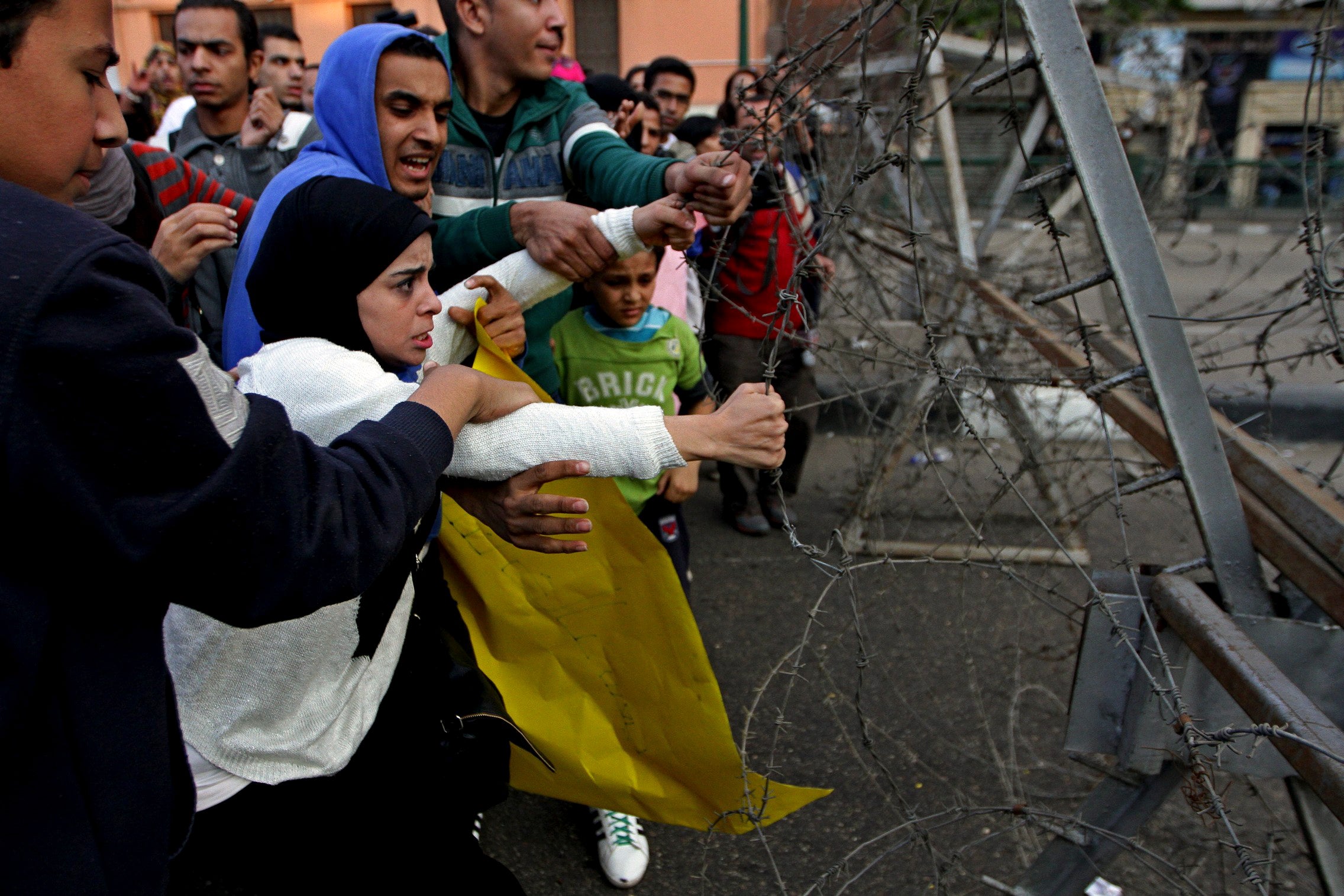 Egyptian anti-government protesters pull on barbed wire separating them from security forces on Saturday.