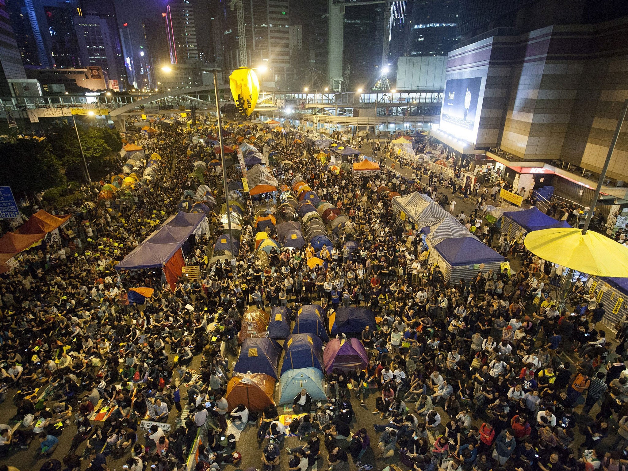 Pro-democracy student protesters in Hong Kong listen to speeches in the Occupy Central zone before clashing with police