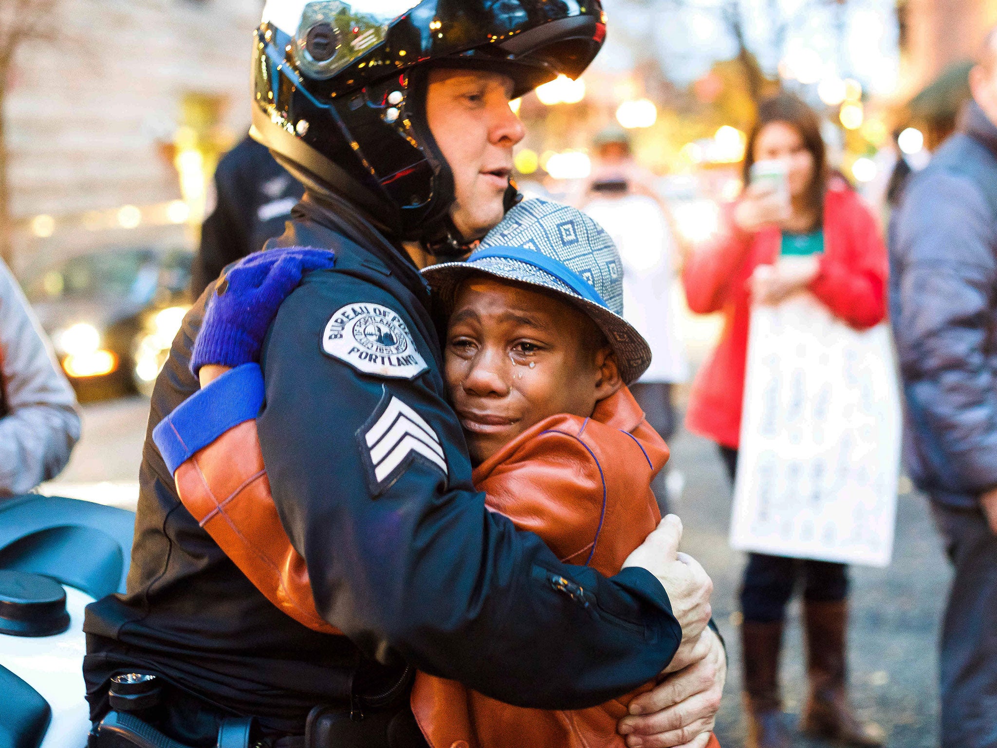Portland police Sgt. Bret Barnum, left, and Devonte Hart, 12, hug at a rally in Portland, Ore., where people had gathered in support of the protests in Ferguson