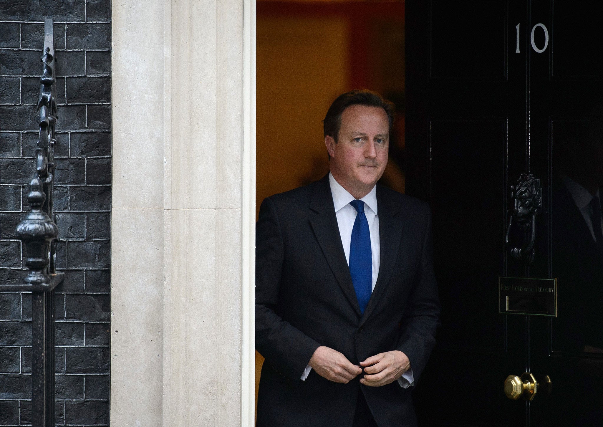 Cameron stands at the door of 10 Downing Street