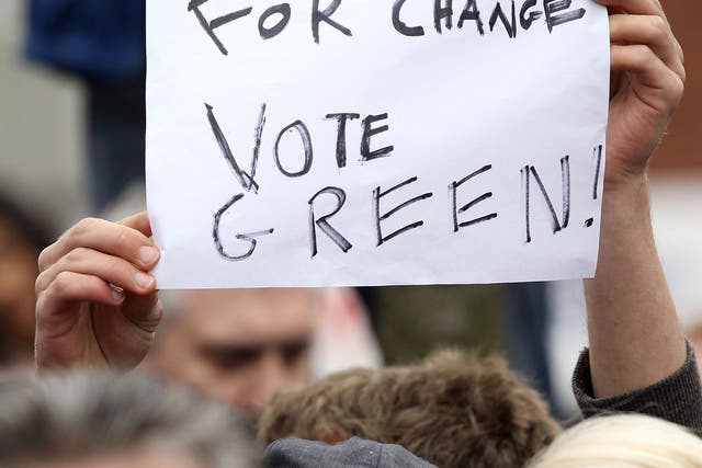 A Green Party supporter holds a placard 