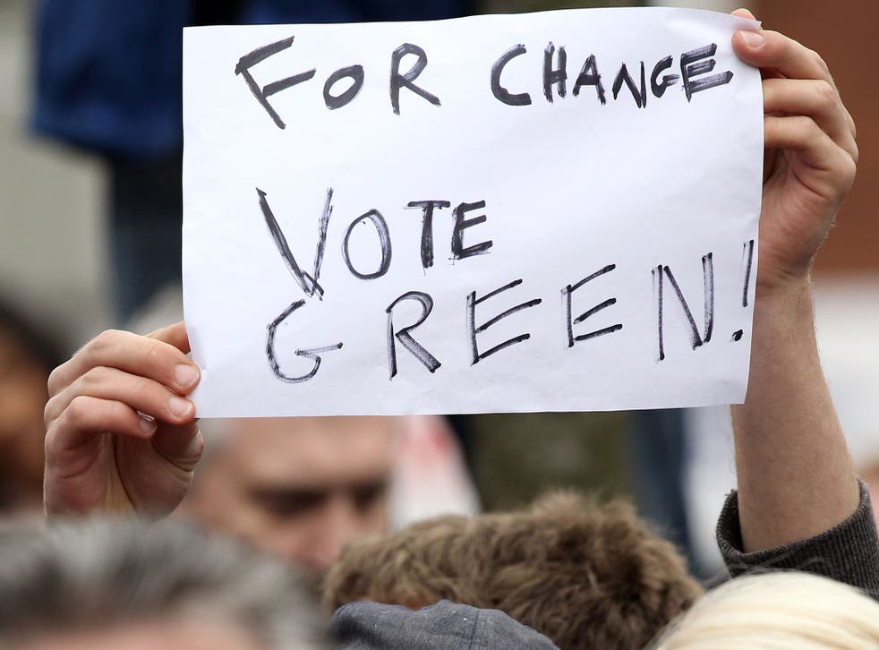 A Green Party supporter holds a placard 