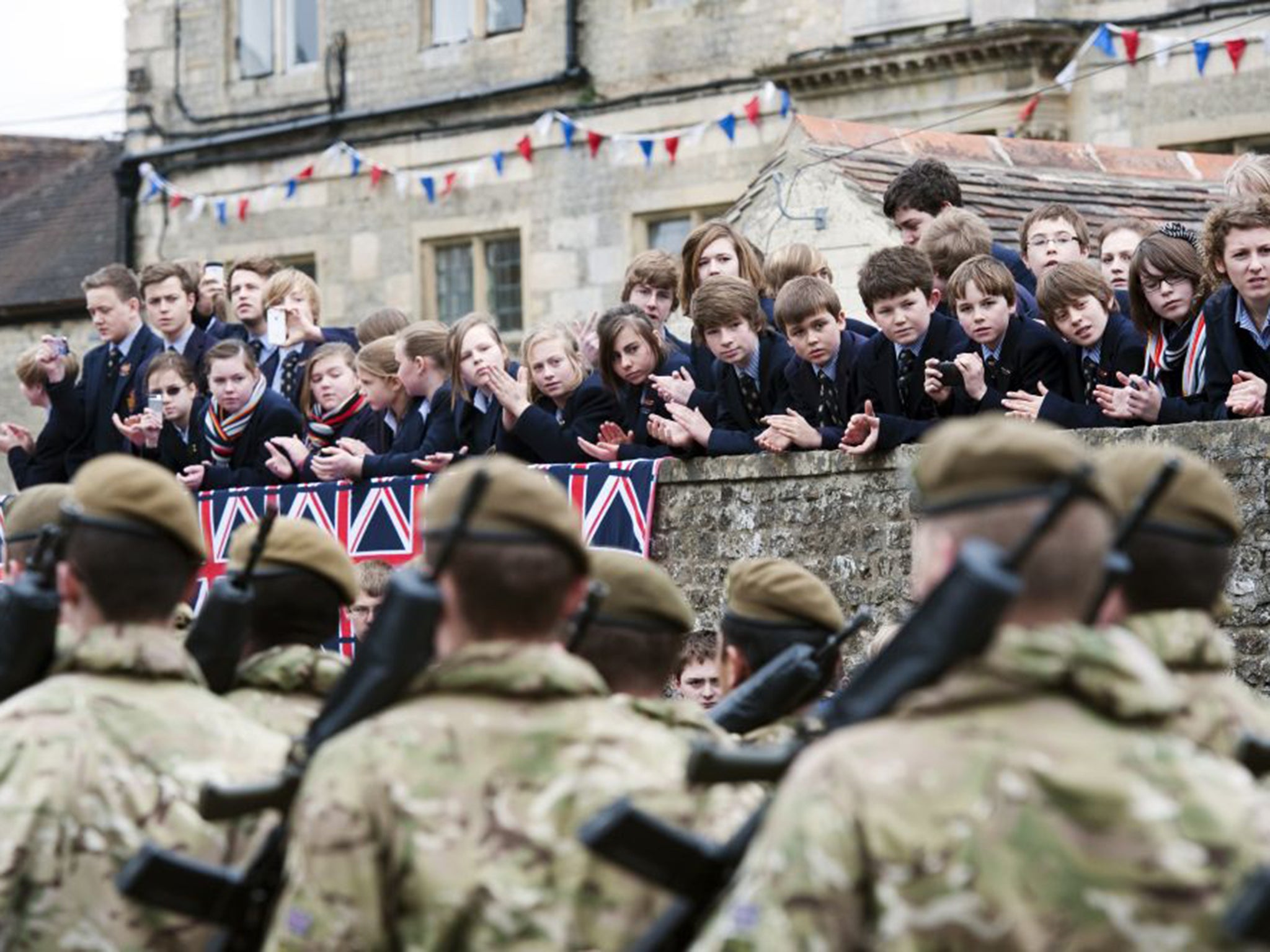 Schoolchildren watch soldiers from 3rd Battalion The Yorkshire Regiment march through Warminster in Wiltshire
