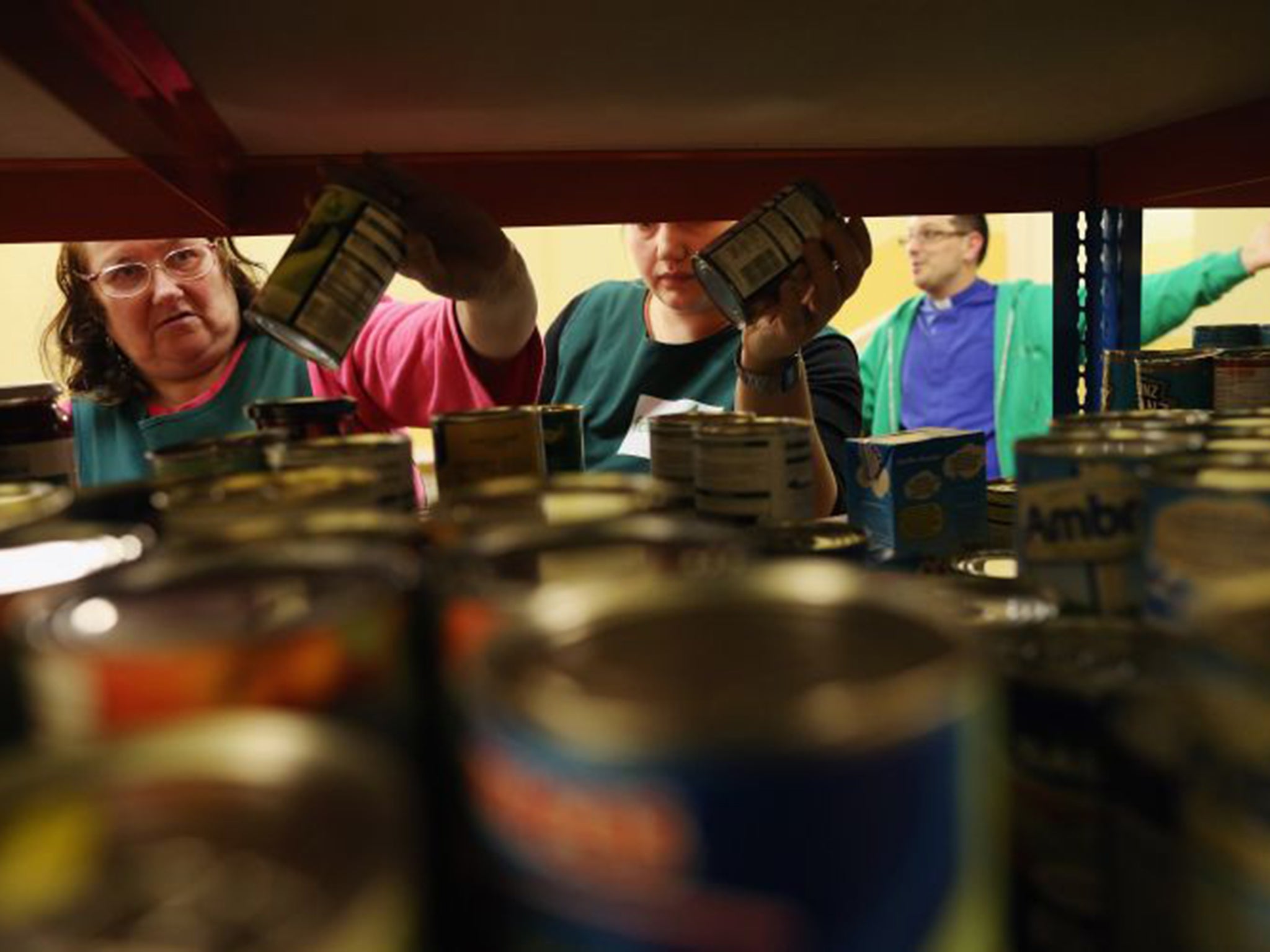Volunteers assemble a selection of tinned food for a client at a food bank depot in Brixton, south London