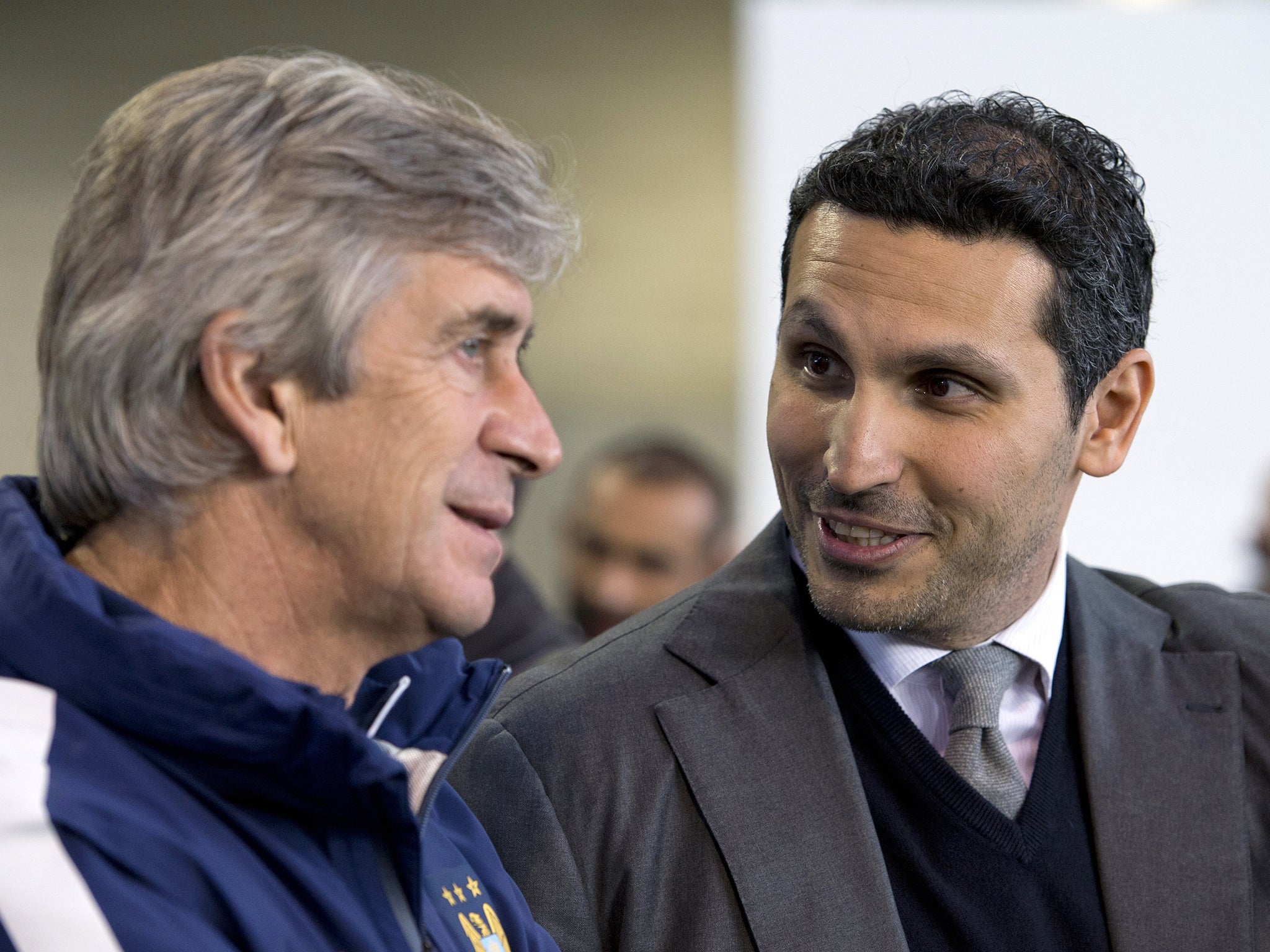 Manchester City's Emirati chairman Khaldoon al-Mubarak (R) chats with Manchester City's Chilean manager Manuel Pellegrini