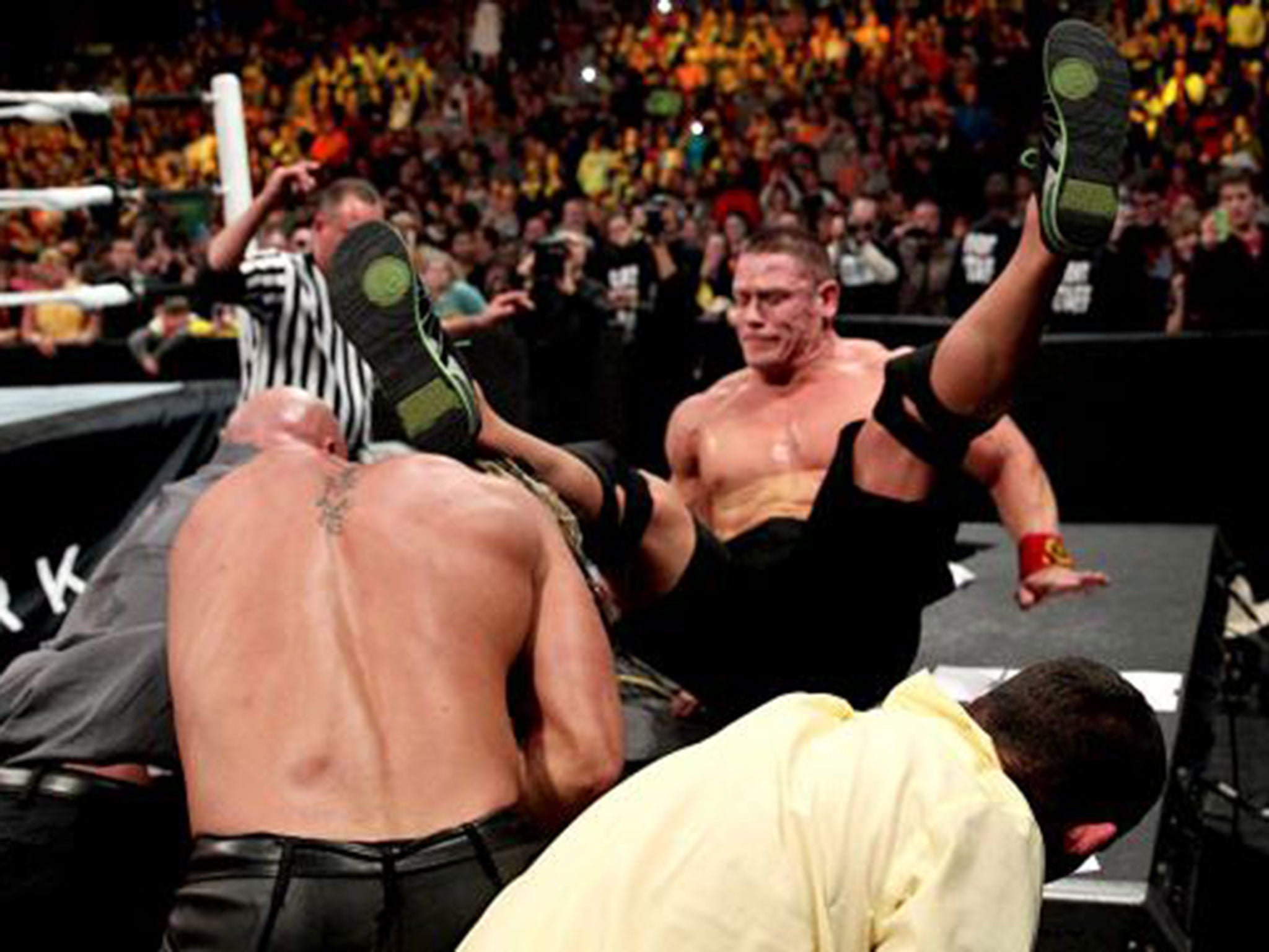 Seth Rollins throws John Cena through the announcers table