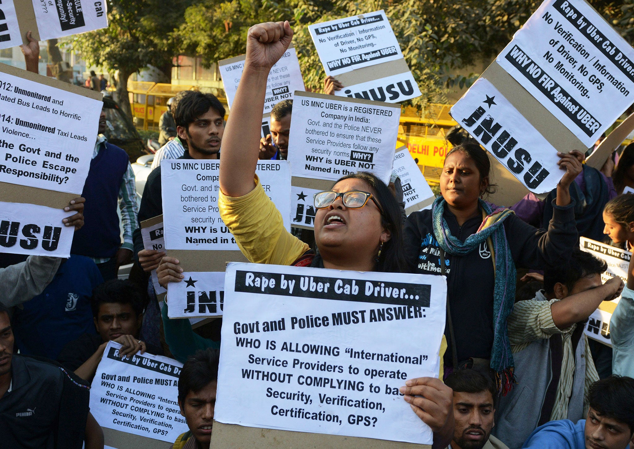 Indian residents hold placards as they take part in a protest against the alleged rape of a passenger by a driver working for the Uber taxi company in New Delhi on December 7, 2014