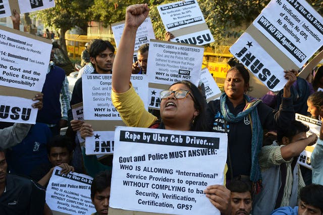 Indian residents hold placards as they take part in a protest against the alleged rape of a passenger by a driver working for the Uber taxi company in New Delhi on December 7, 2014