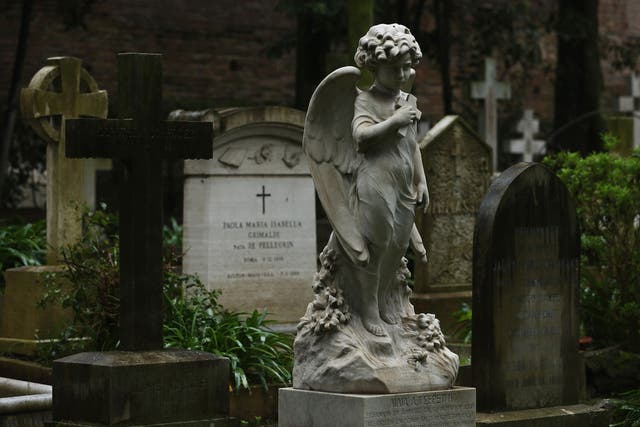 A gravestone stands in a cemetary 