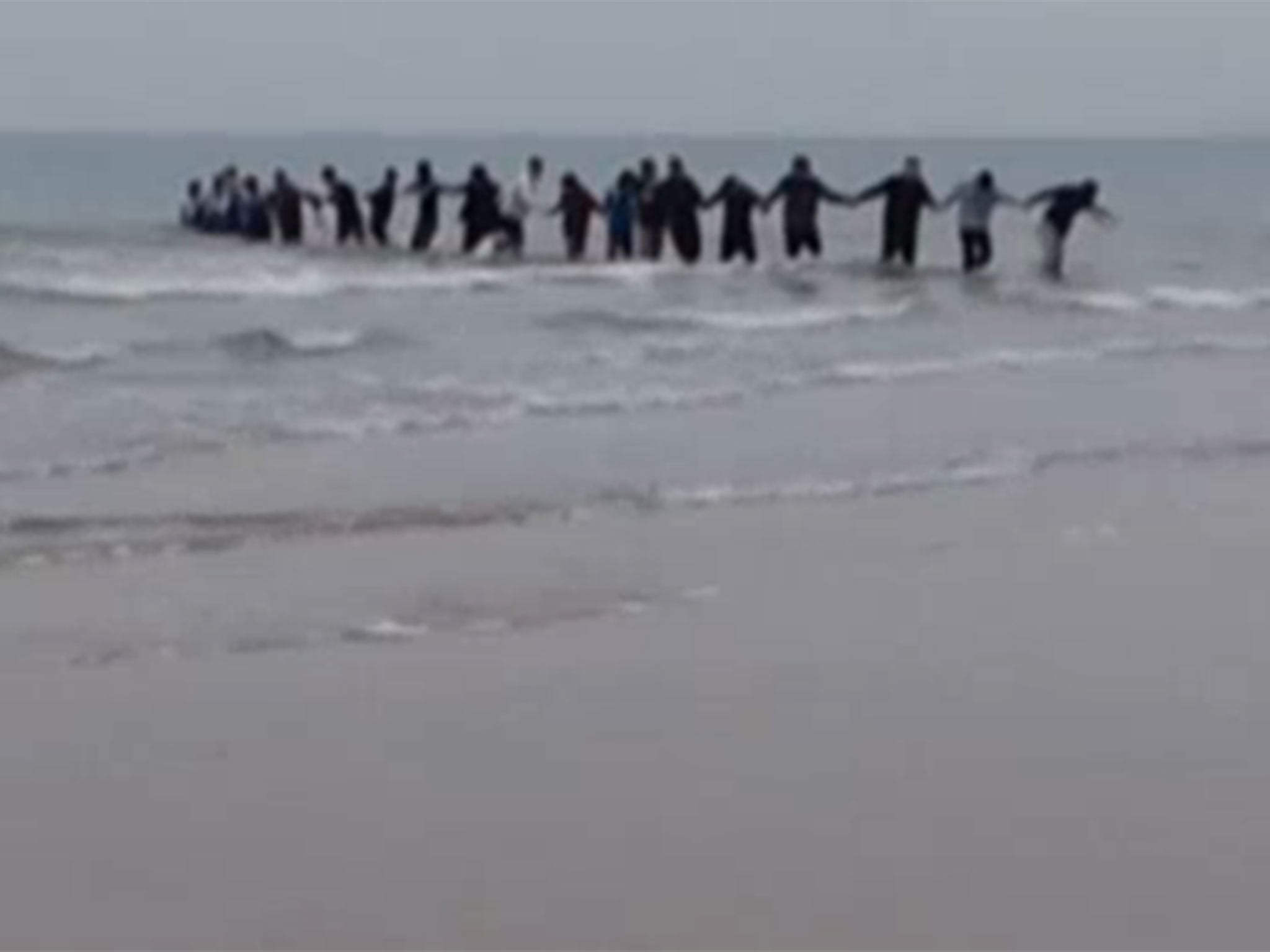 University students in China have rescued a woman who was apparently attempting to commit suicide in freezing sea water by forming a human chain.