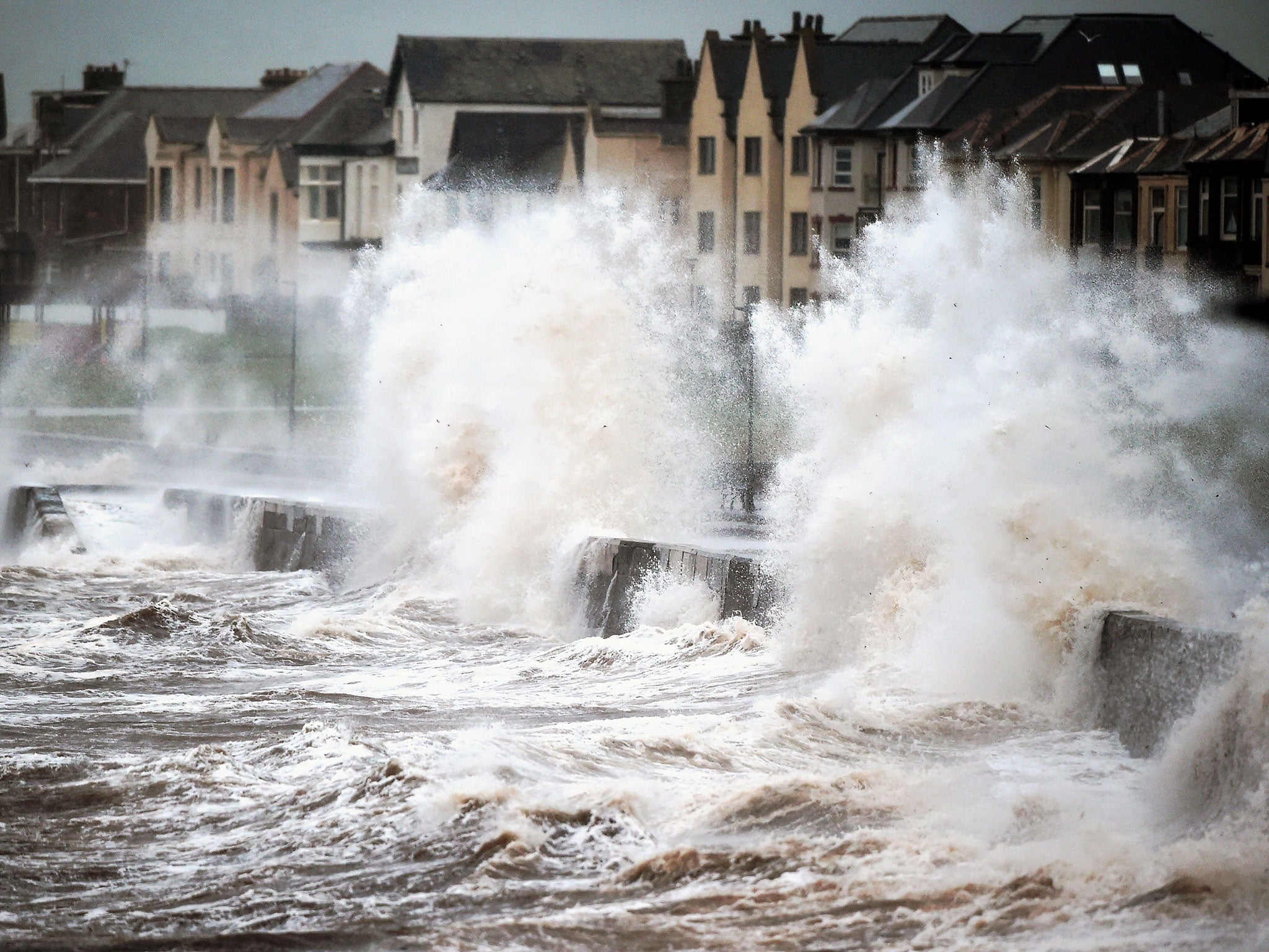 Waves crash over the promenade wall in Prestwick, Scotland.