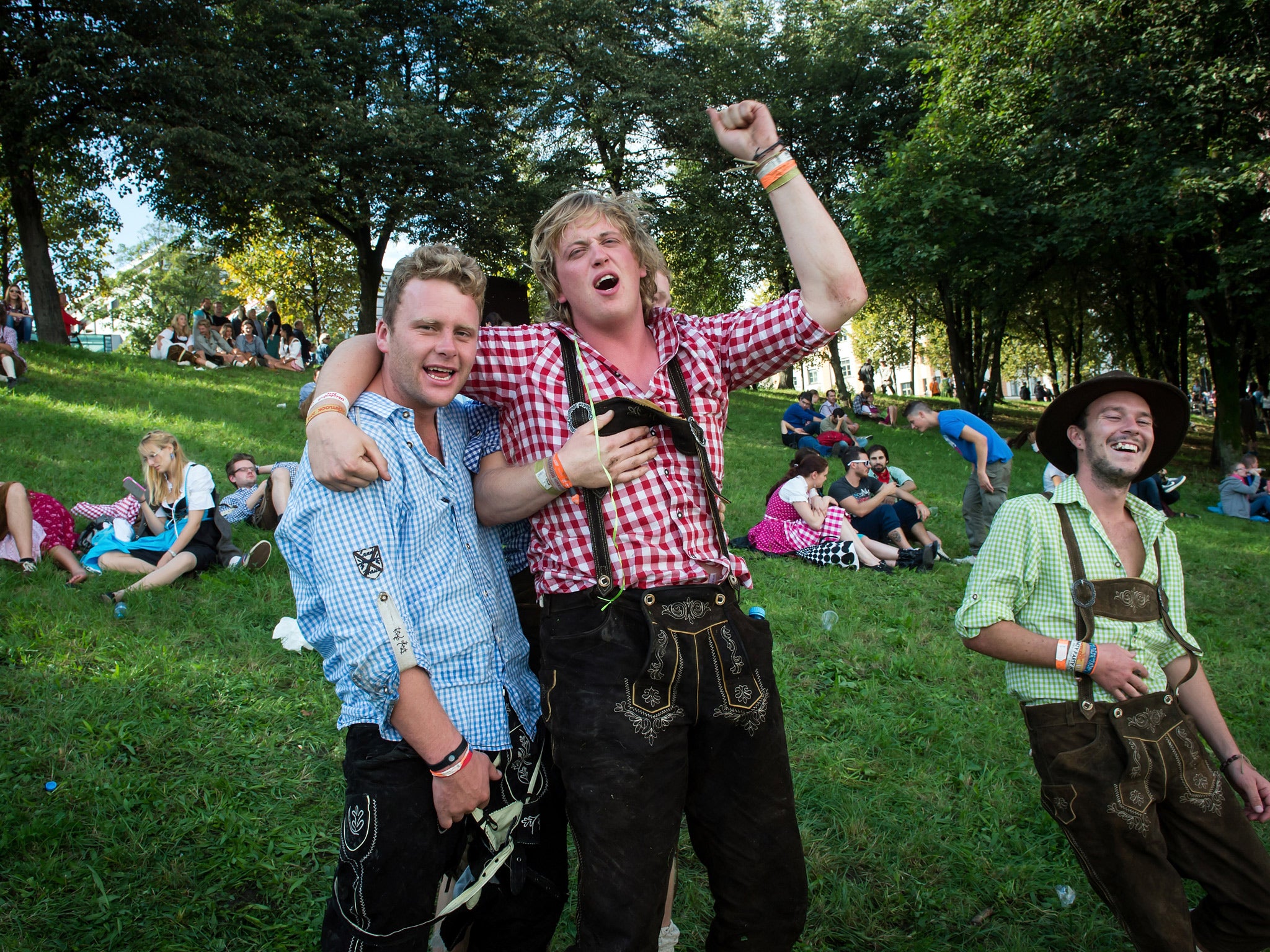 Drunken or tired visitors in traditional bavarian clothes take a rest during the opening day of the 2014 Oktoberfest