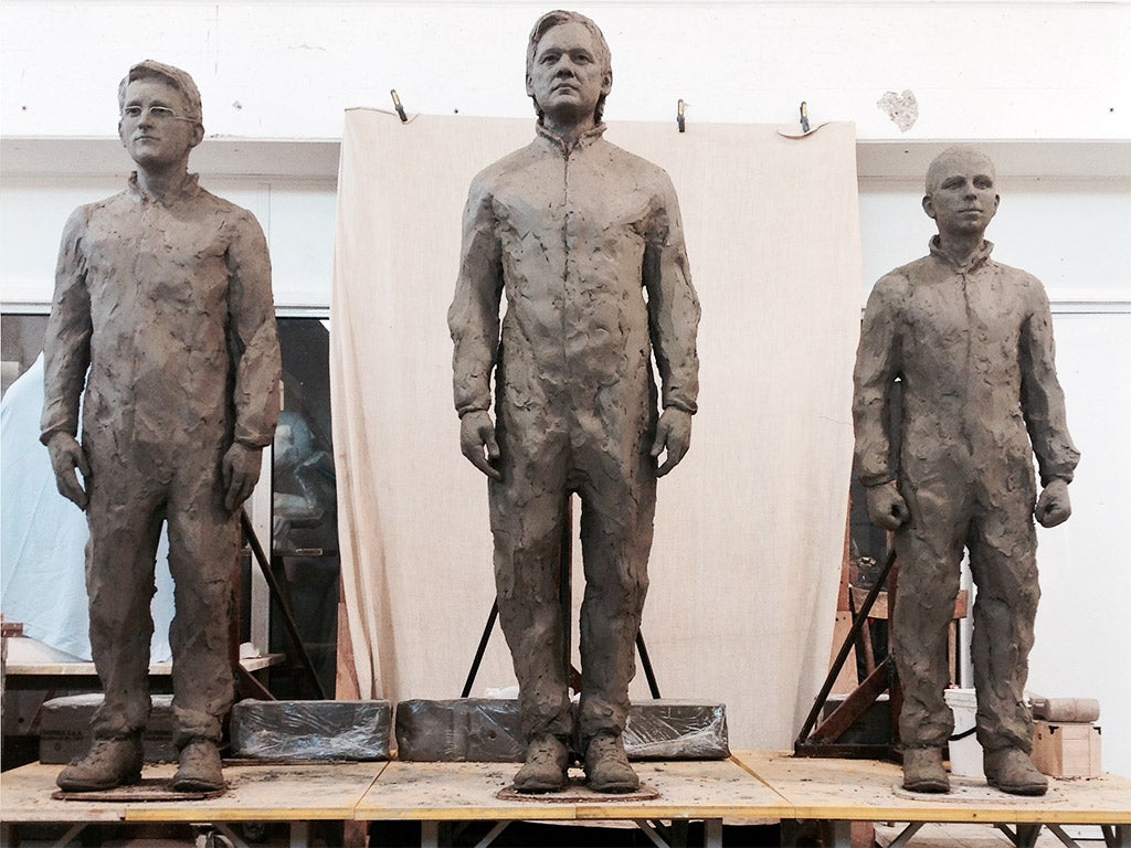 The statue of Julian Assange stands between sculptures of Edward Snowden, left, and Chelsea Manning