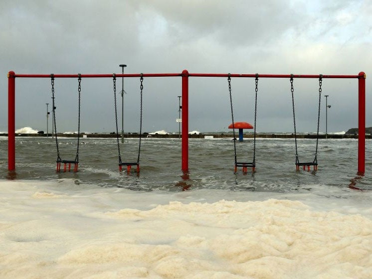 Waves flood a children's play park in Portstewart in northern Ireland (Reuters)