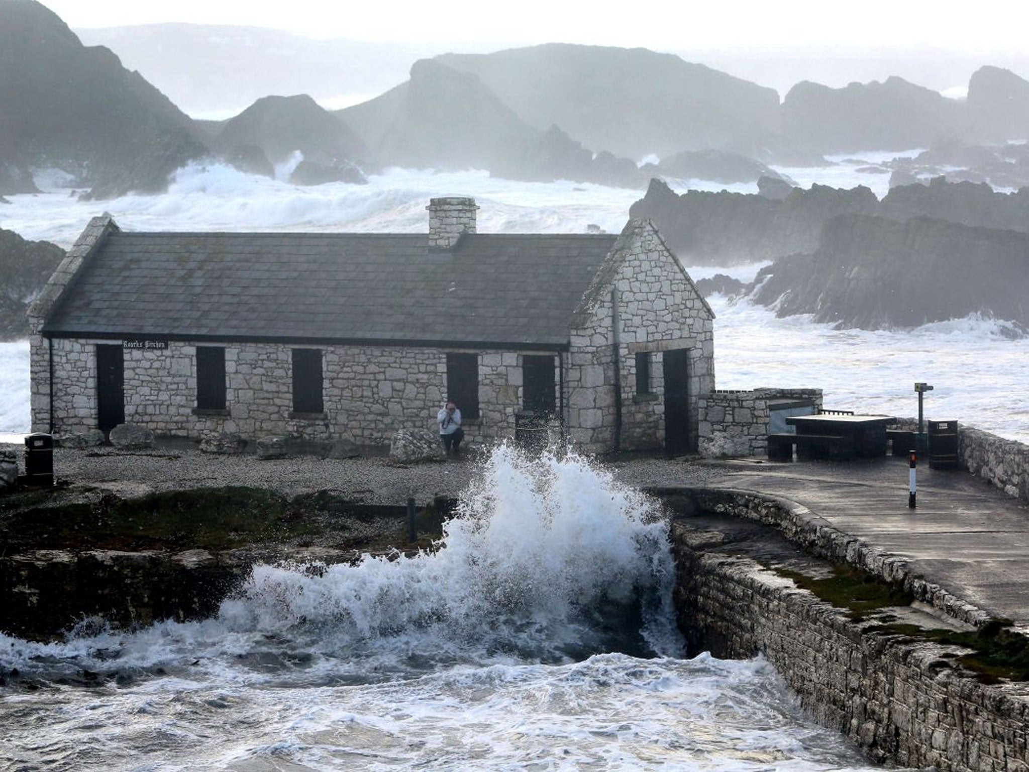 Large waves batter the harbour wall during stormy weather in Ballinto in Northern Ireland.