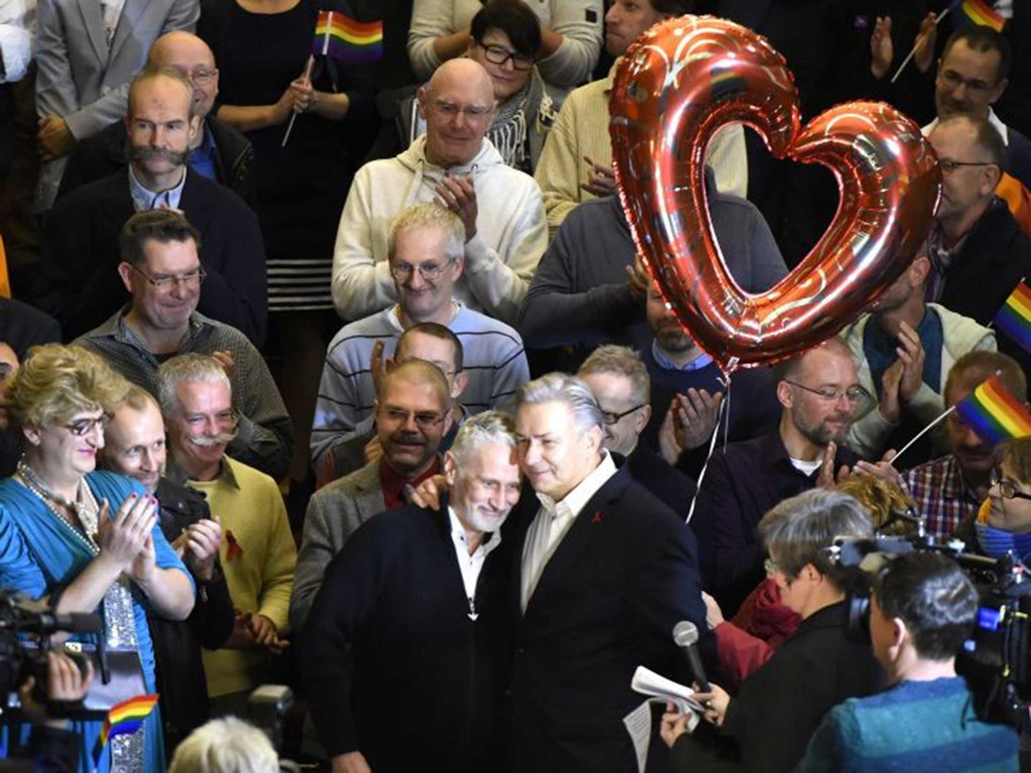 Klaus Wowereit, centre right, hugs his partner Jörn Kubicki during a farewell party organised by Berlin’s gay communities at the town hall
