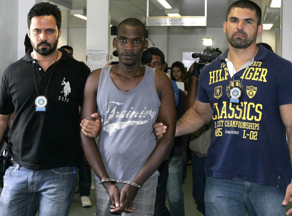 Sailson Jose das Gracas, 26, is escorted by policemen at a police station in Nova Iguacu near Rio de Janeiro December 11, 2014