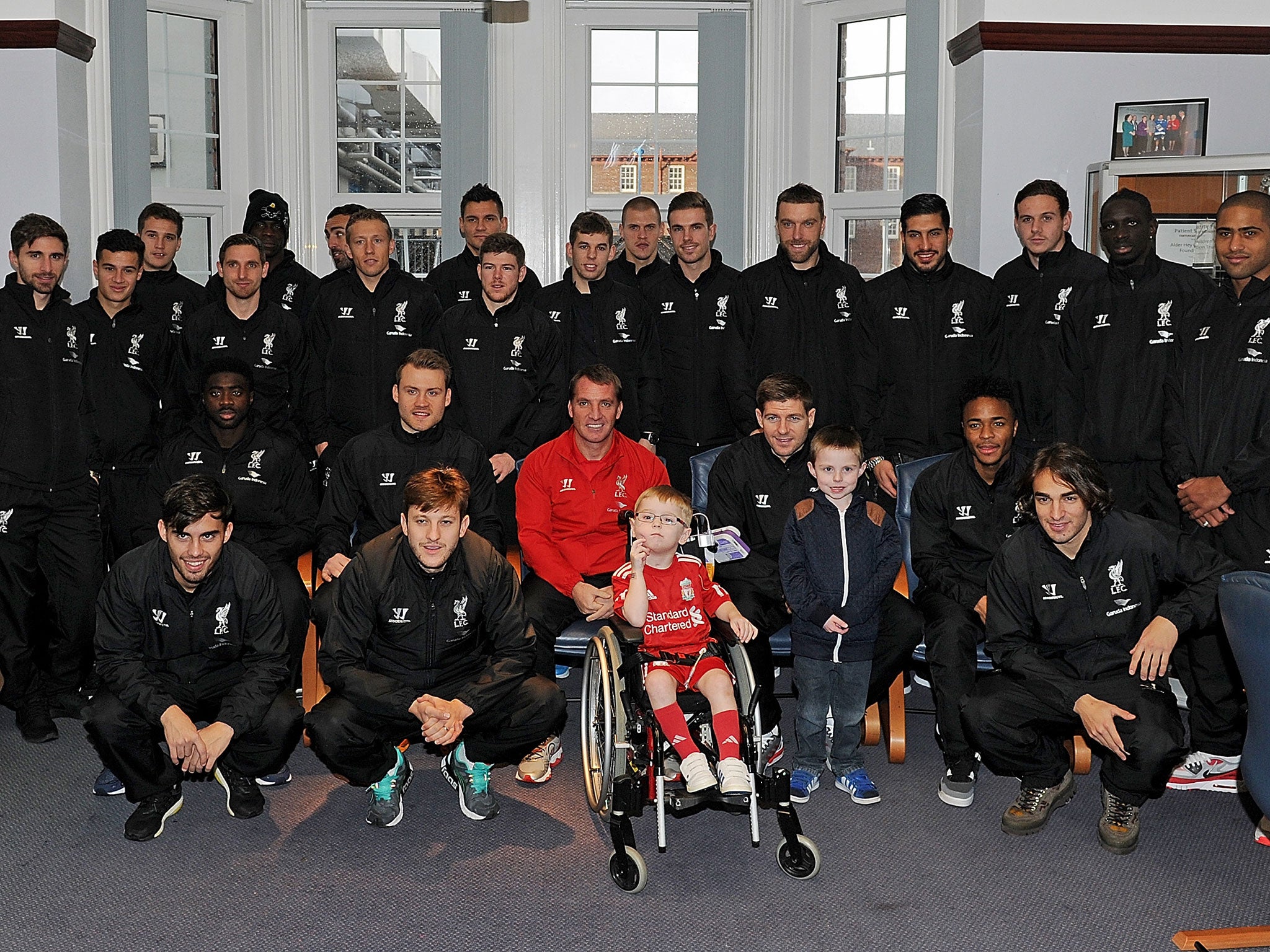 The entire Liverpool squad pictured alongside Brendan Rodgers and two young boys at Alder Hey Children's Hospital