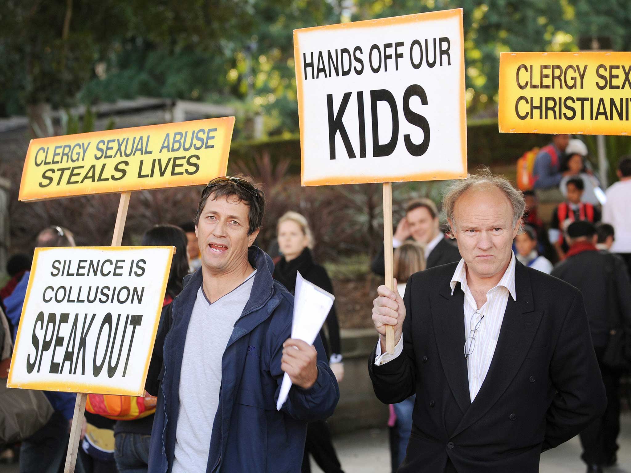 Activists protesting sexual abuse in the Catholic church hold up placards outside St Mary's Cathedral in Sydney