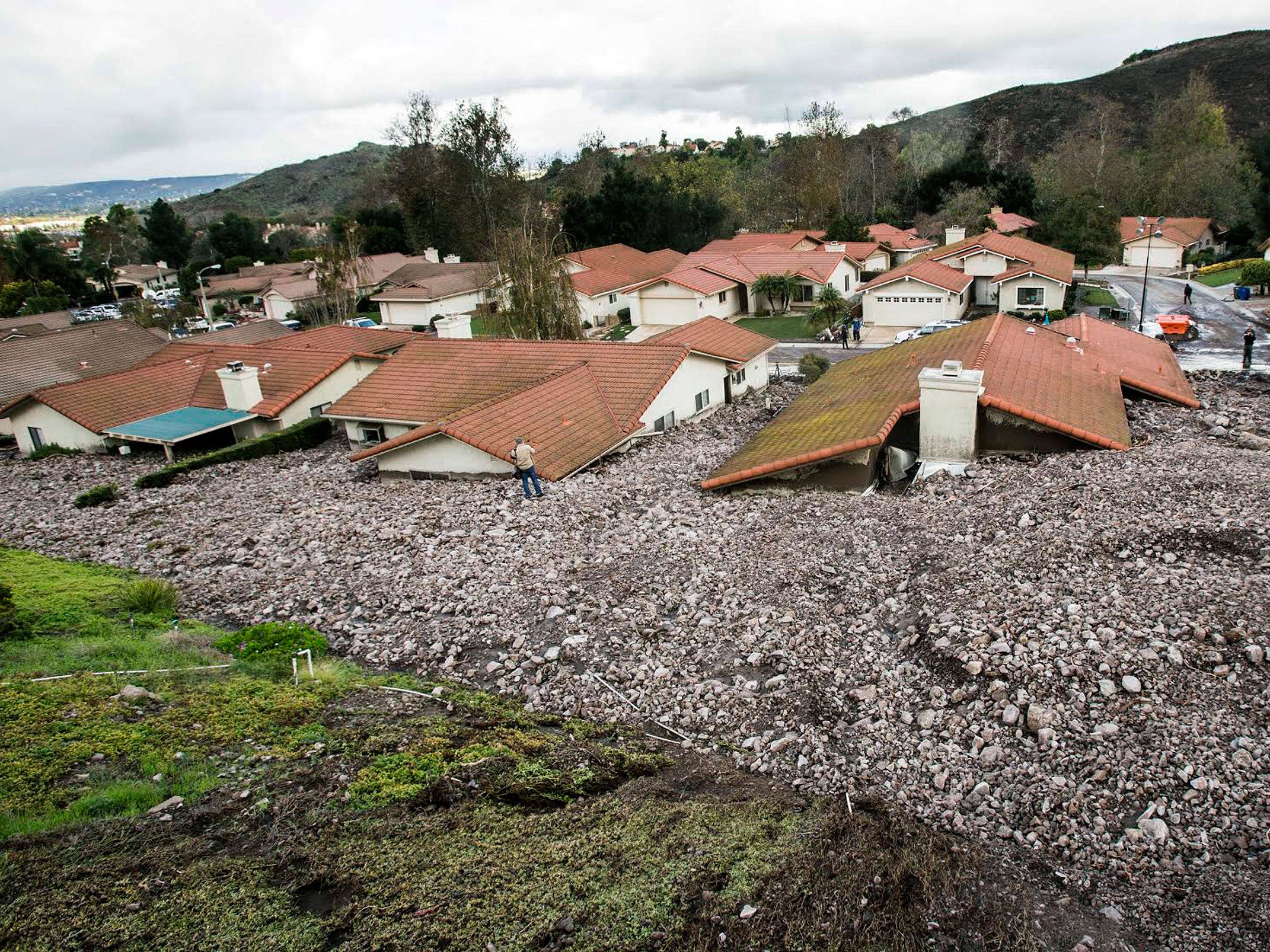 Debris and rocks fill the gardens of homes along San Como Lane in Camarillo Springs, Calif., after a storm on 12 December 2014