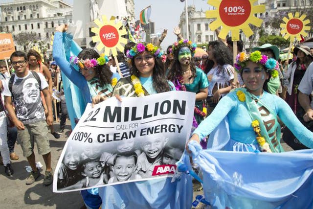 Protestors at the People's Climate March in Lima, Peru calling for the ministers at the UN Climate talks to agree to a global shift to 100 per cent clean energy by 2050