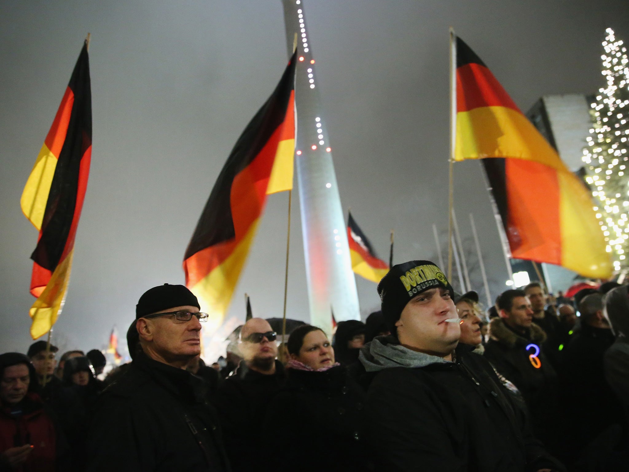 Supporters of the Pegida movement hold up German flags as they gather to protest on December 8, 2014 in Duesseldorf, Germany