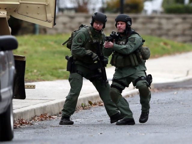 Police move near the scene of a shooting in Souderton, Pa. Police are surrounding a home in Souderton, outside Philadelphia, where a suspect is believed to have barricaded himself after shootings at multiple homes. Police tell WPVI-TV the man is suspected