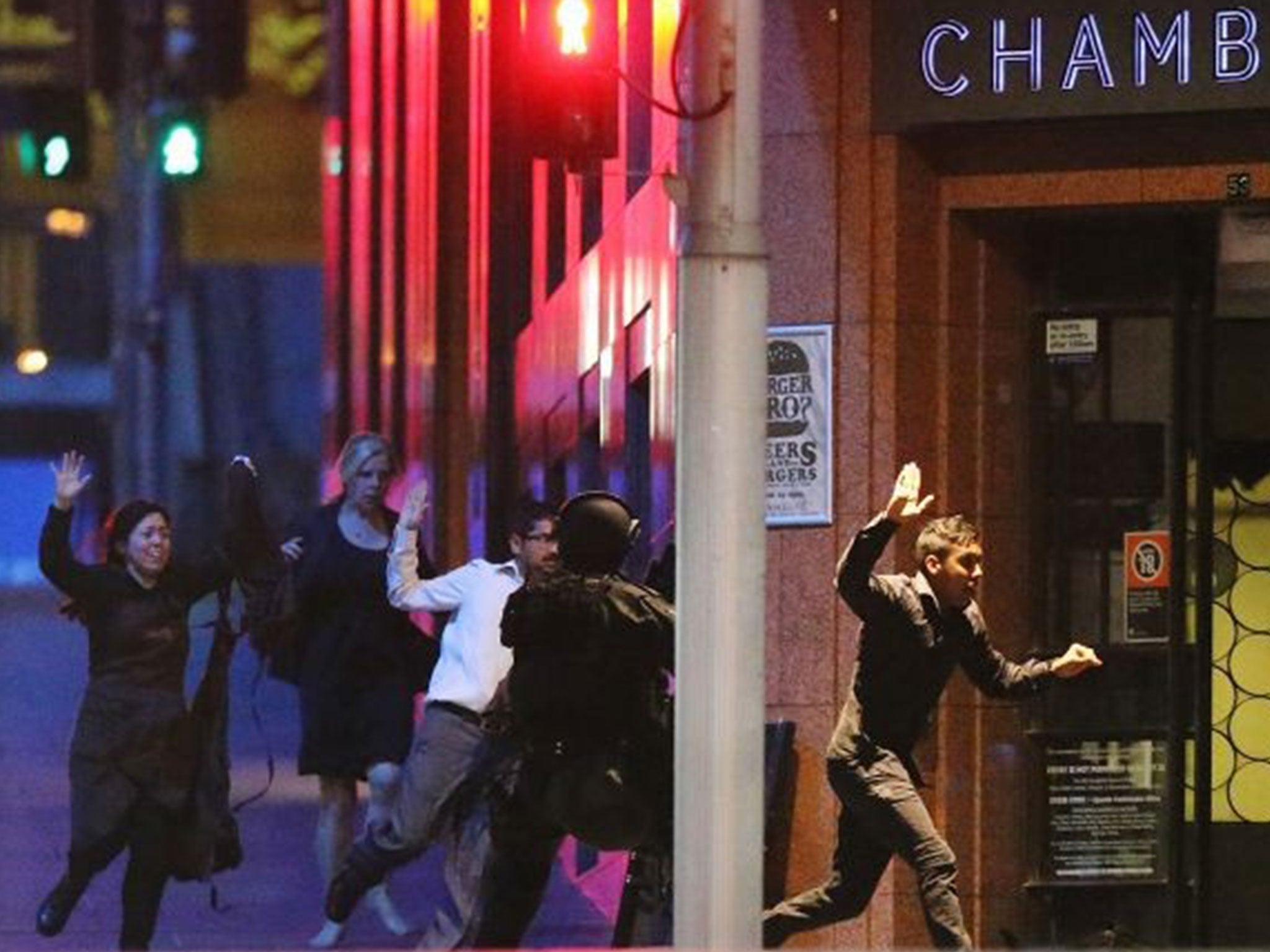 People run with hands up from the Lindt Cafe as police stormed the Sydney cafe where a gunman was holding hostages