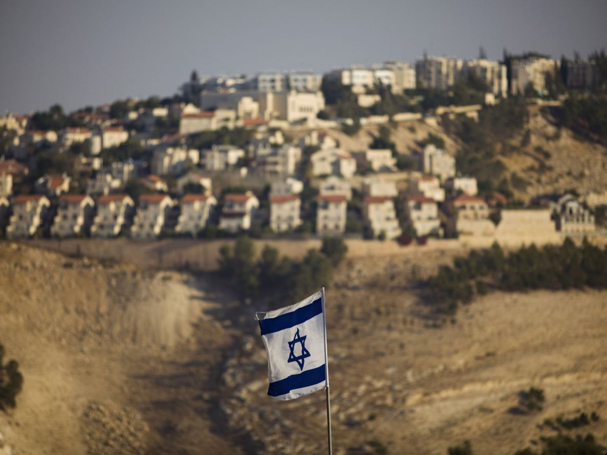 An Israeli flag flies in front of the West Bank Jewish settlement of Maaleh Adumim on the outskirts of Jerusalem in 2009 (AP)