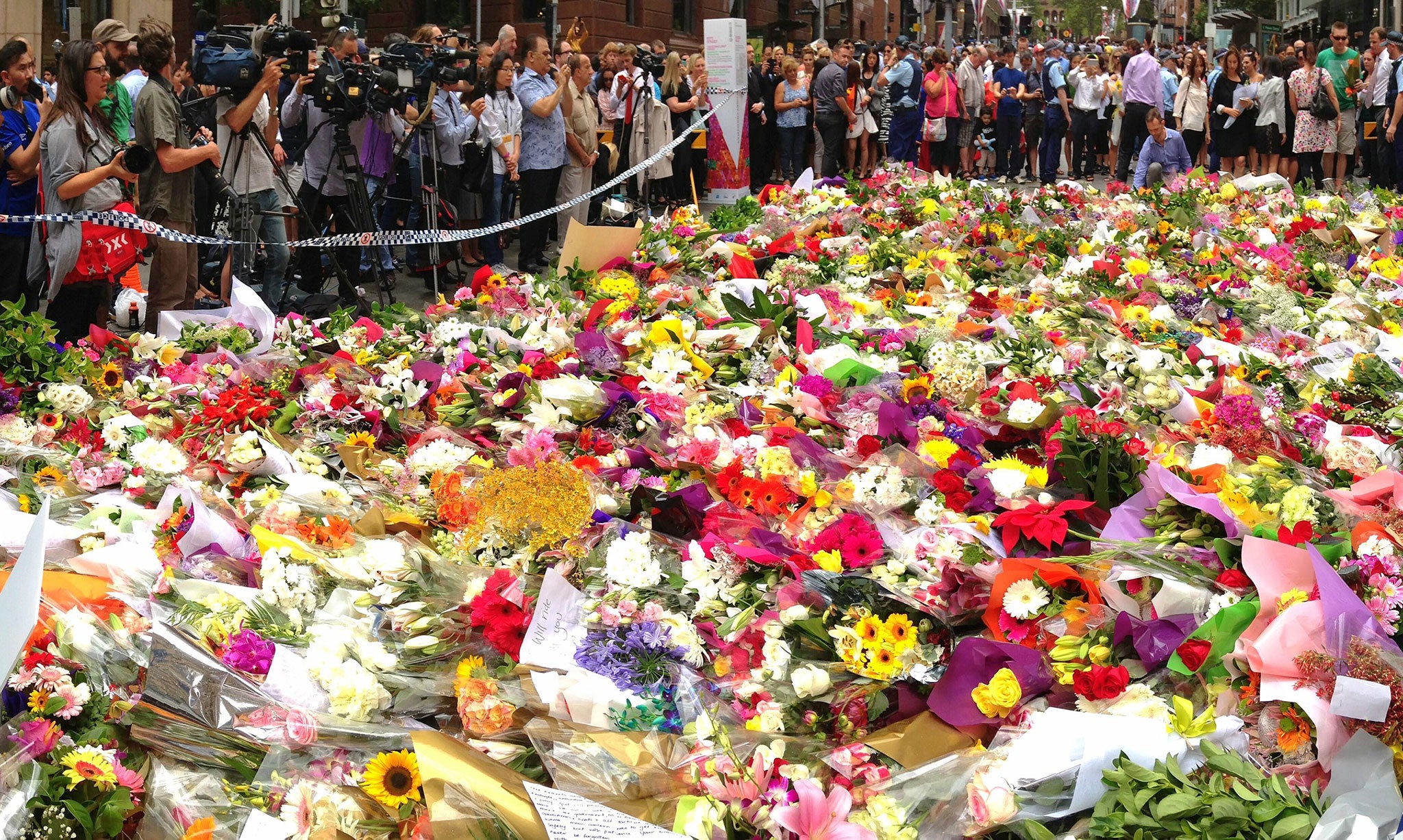 Sydneysiders visit the floral memorial for victims Tori Johnson and Katrina Dawson at the scene of the Martin Place siege in the CBD in Sydney