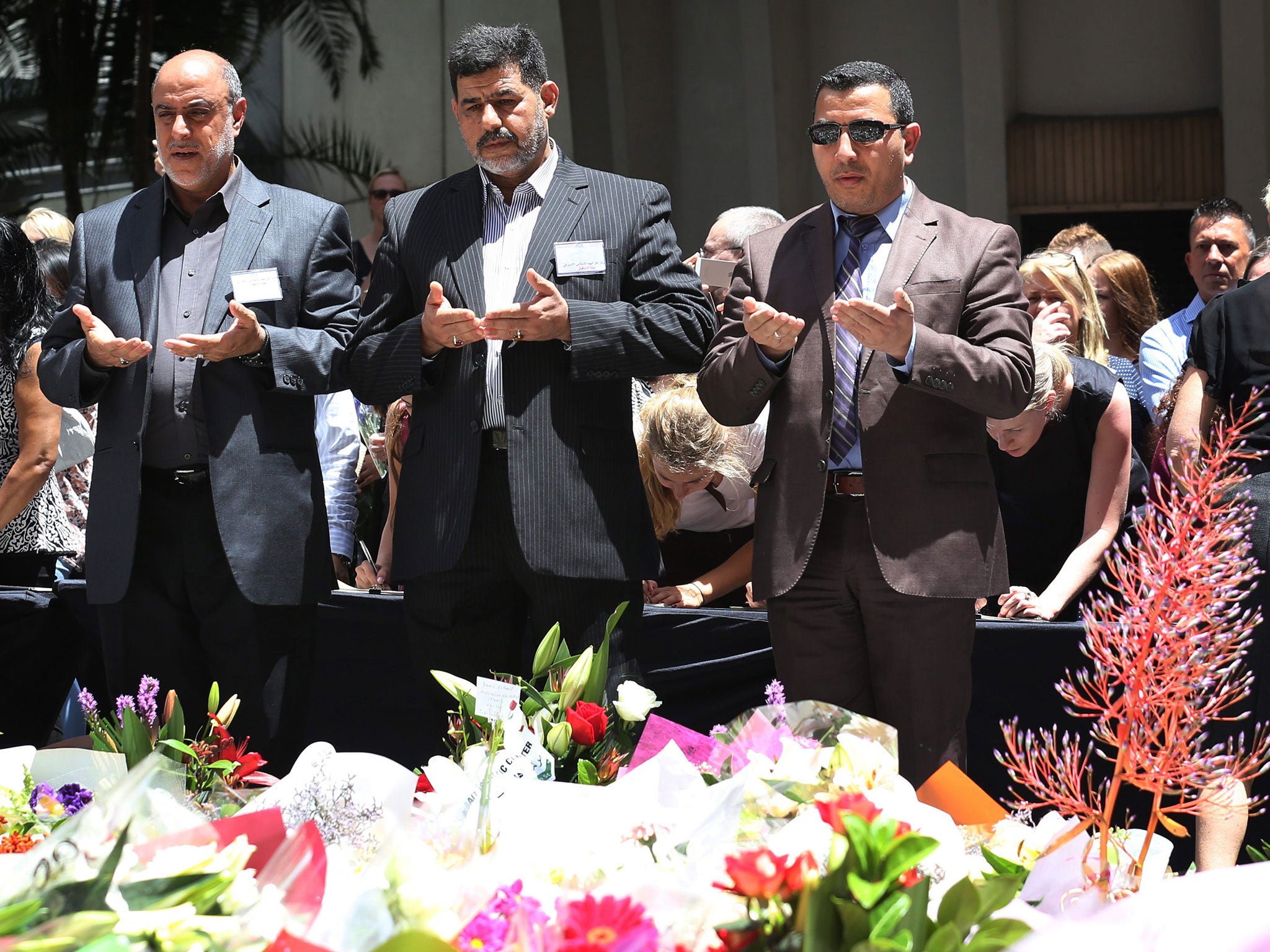 Others pray near the site of the dramatic siege