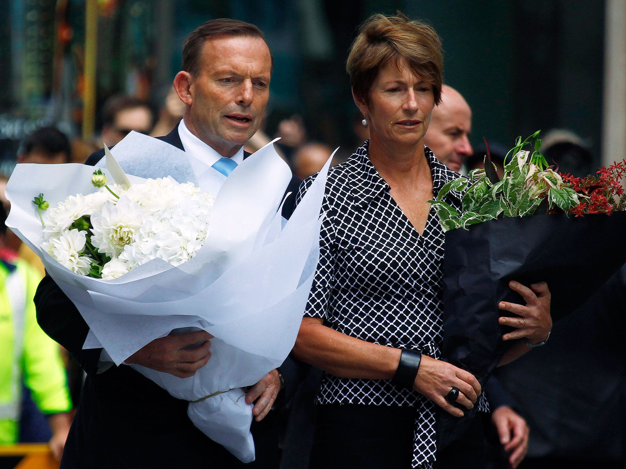 Australian Prime Minister Tony Abbott and his wife Margie prepare to place floral tributes near the cafe in central Sydney