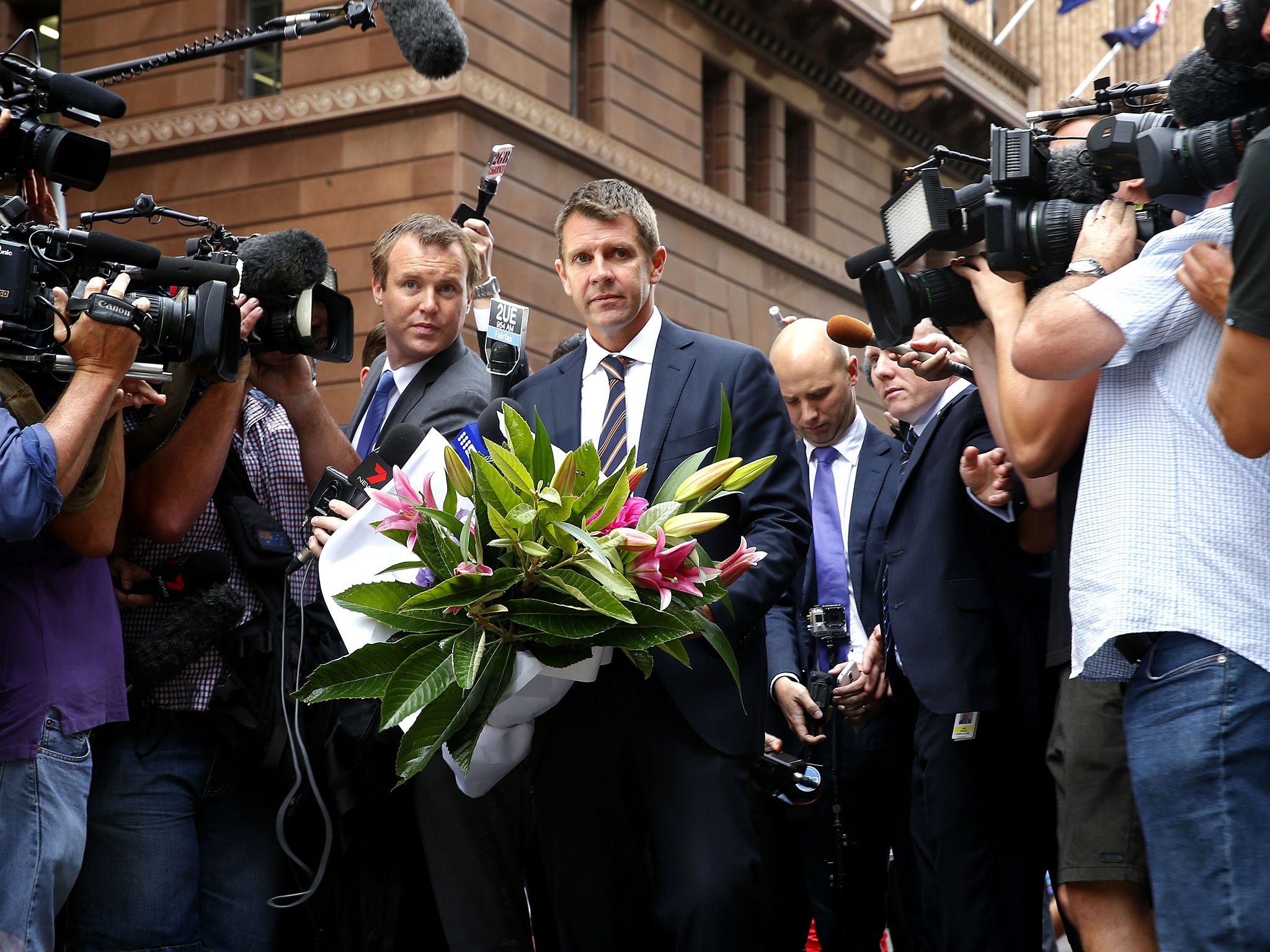 Premier Mike Baird visits the floral memorial for victims Tori Johnson and Katrina Dawson at the scene of the Martin Place siege in the CBD in Sydney