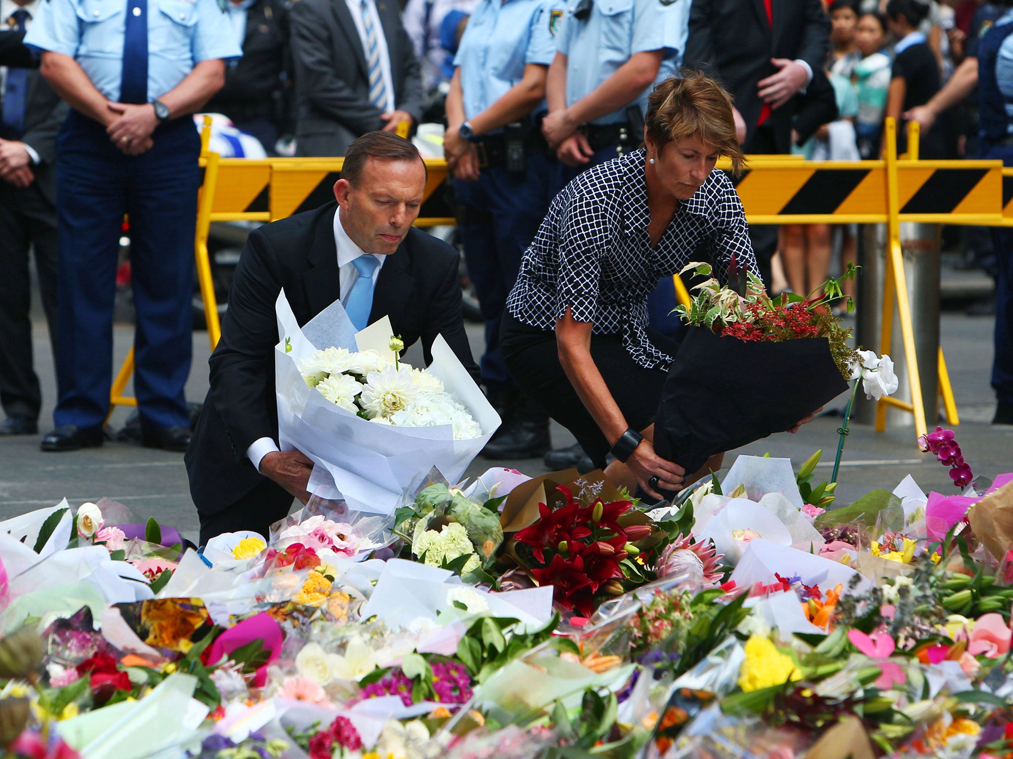 Australian Prime Minister Tony Abbott and his wife Margie pay their respect to the victims of the siege in Martin Place in Sydney central business district