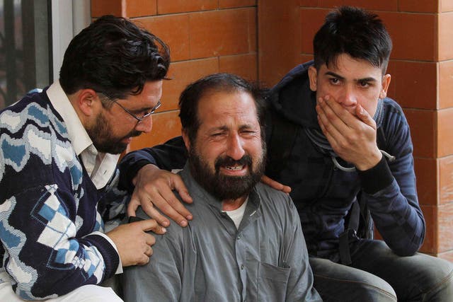 Relatives of a student, who was injured during an attack by Taliban gunmen on the Army Public School, comfort each other outside Lady Reading Hospital in Peshawar 