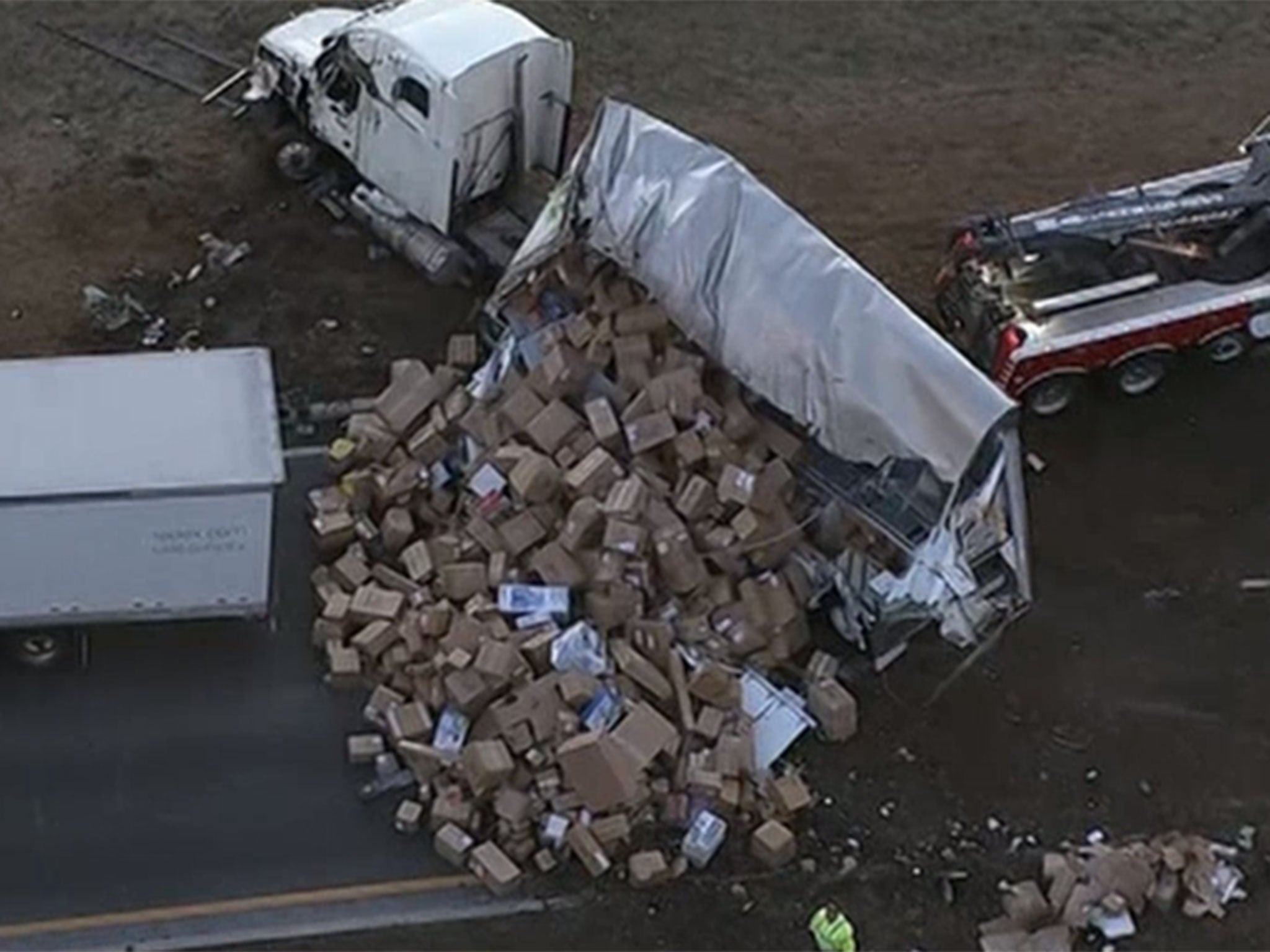 FedEx truck spills hundreds of packages on motorway on the busiest day in the company's history.