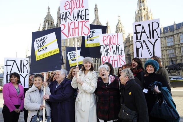 Gemma Arterton (C) holds a placard outside the Houses of Parliament to mark the tabling of the motion on equal pay earlier this year