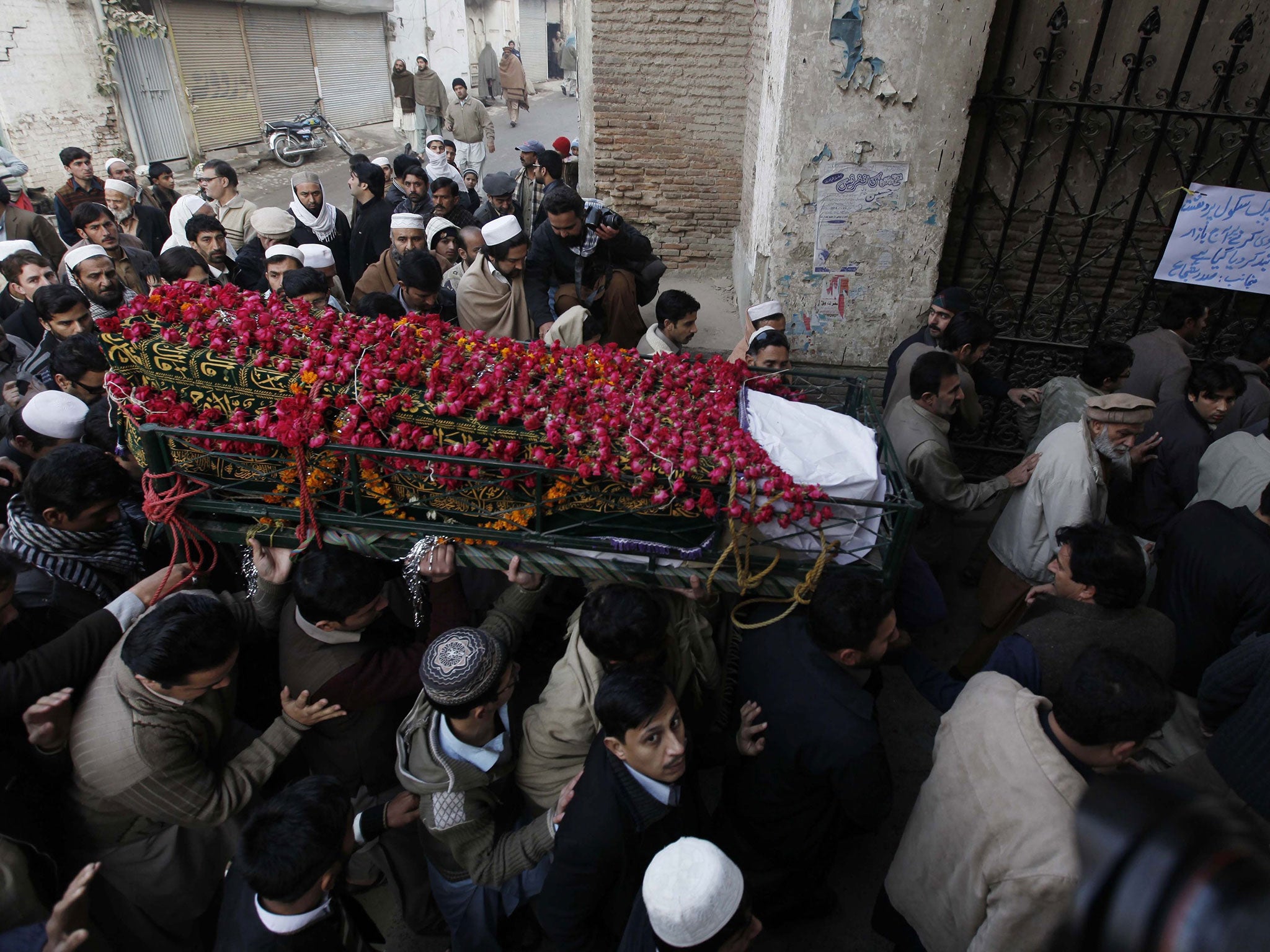 People attend the funeral of two school boys who were killed by Taliban militants at a school run by the Army, in Peshawar, Pakistan