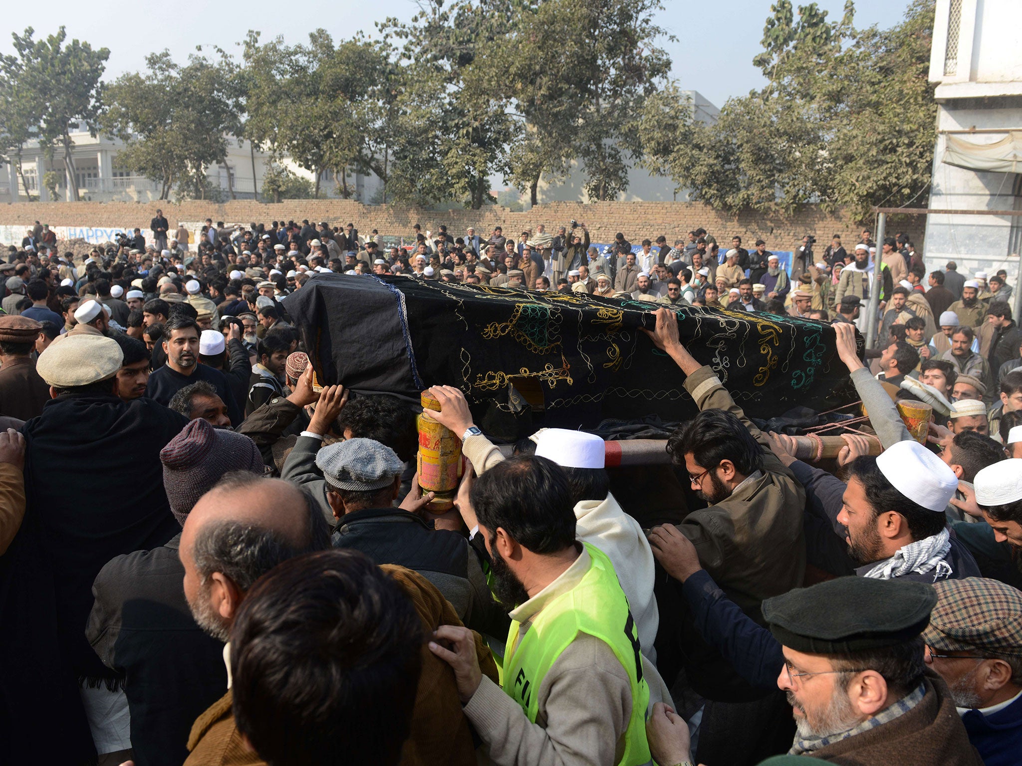 Pakistani mourners carry the coffin of a victim of an attack by militants on an army-run school during a funeral ceremony in Peshawar on December 17