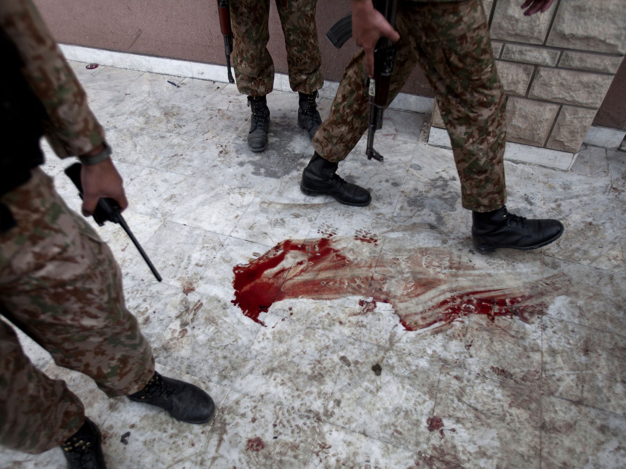 Pakistan army soldiers stand outside the school's auditorium the day after the Taliban attack