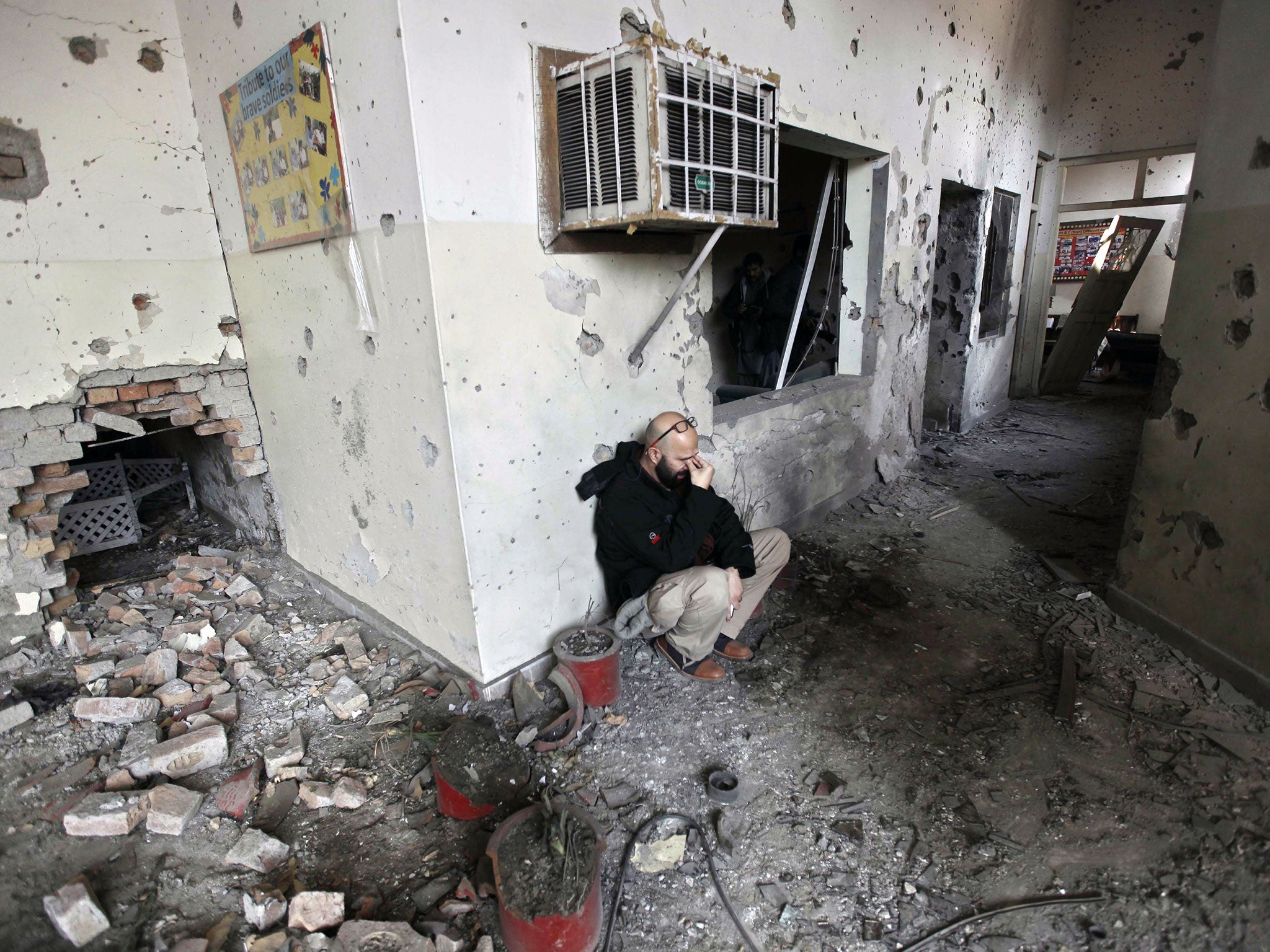 A journalist reacts as he visits the Army Public School that was attacked by the Taliban militants in Peshawar