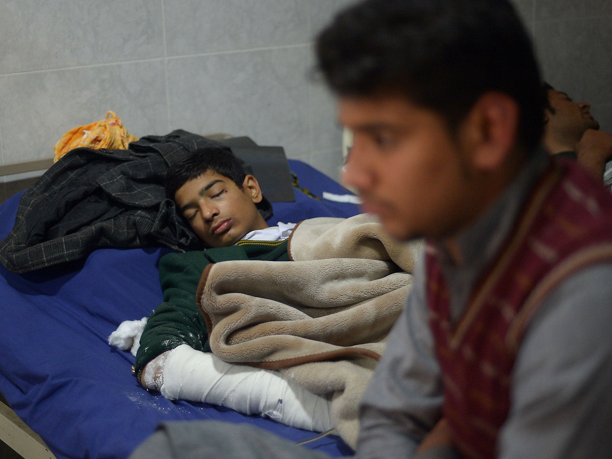 Wounded Pakistani student Mehran rests on a hospital bed after Taliban gunmen attacked a school in Peshawar on December 17, 2014