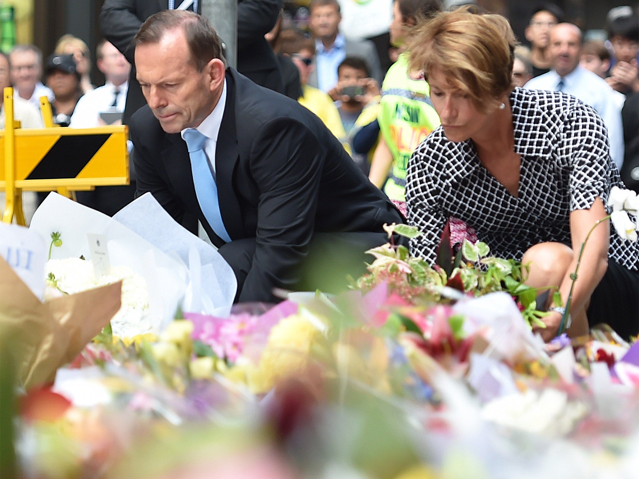 Australian Prime Minister Tony Abbott and his wife Margaret lay wreaths near the scene of the fatal siege