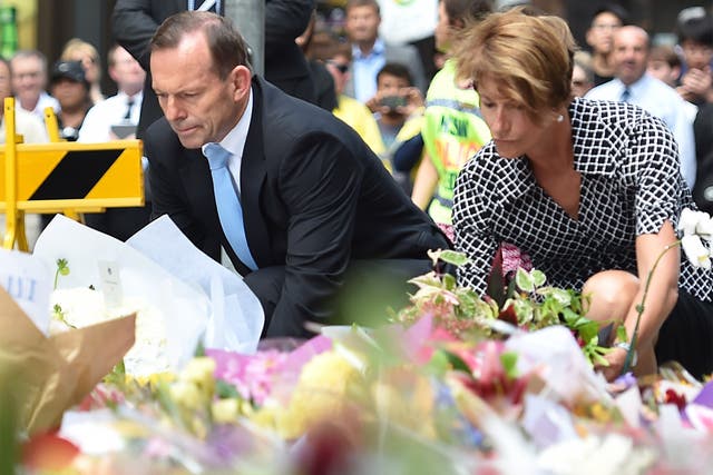 Australian Prime Minister Tony Abbott and his wife Margaret lay wreaths near the scene of the fatal siege
