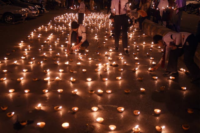 Pakistani students in Karachi light earthen lamps for the victims of the attack in Peshawar