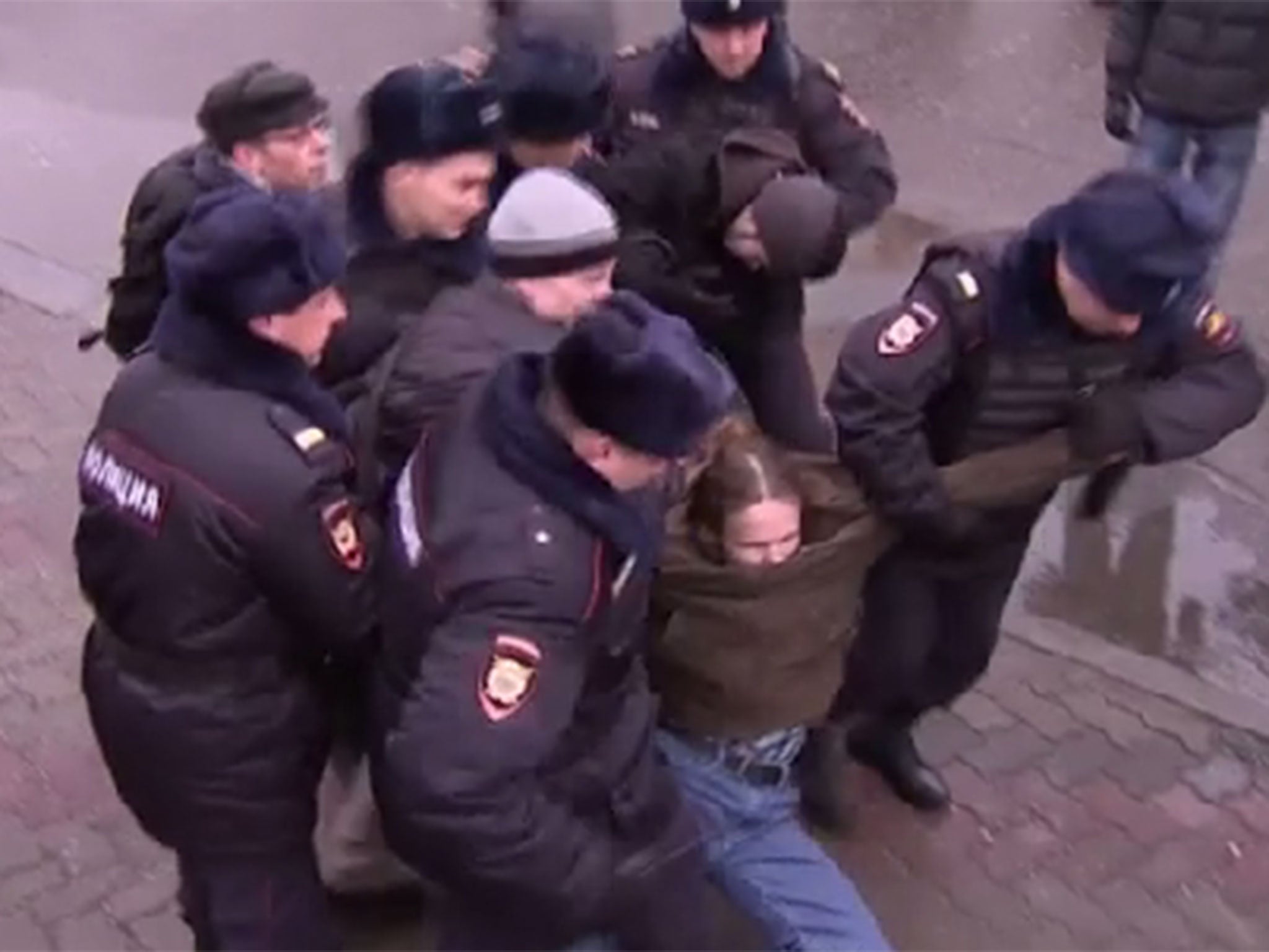 Police arrest protestors trying to get into Vladimir Putin's news conference.